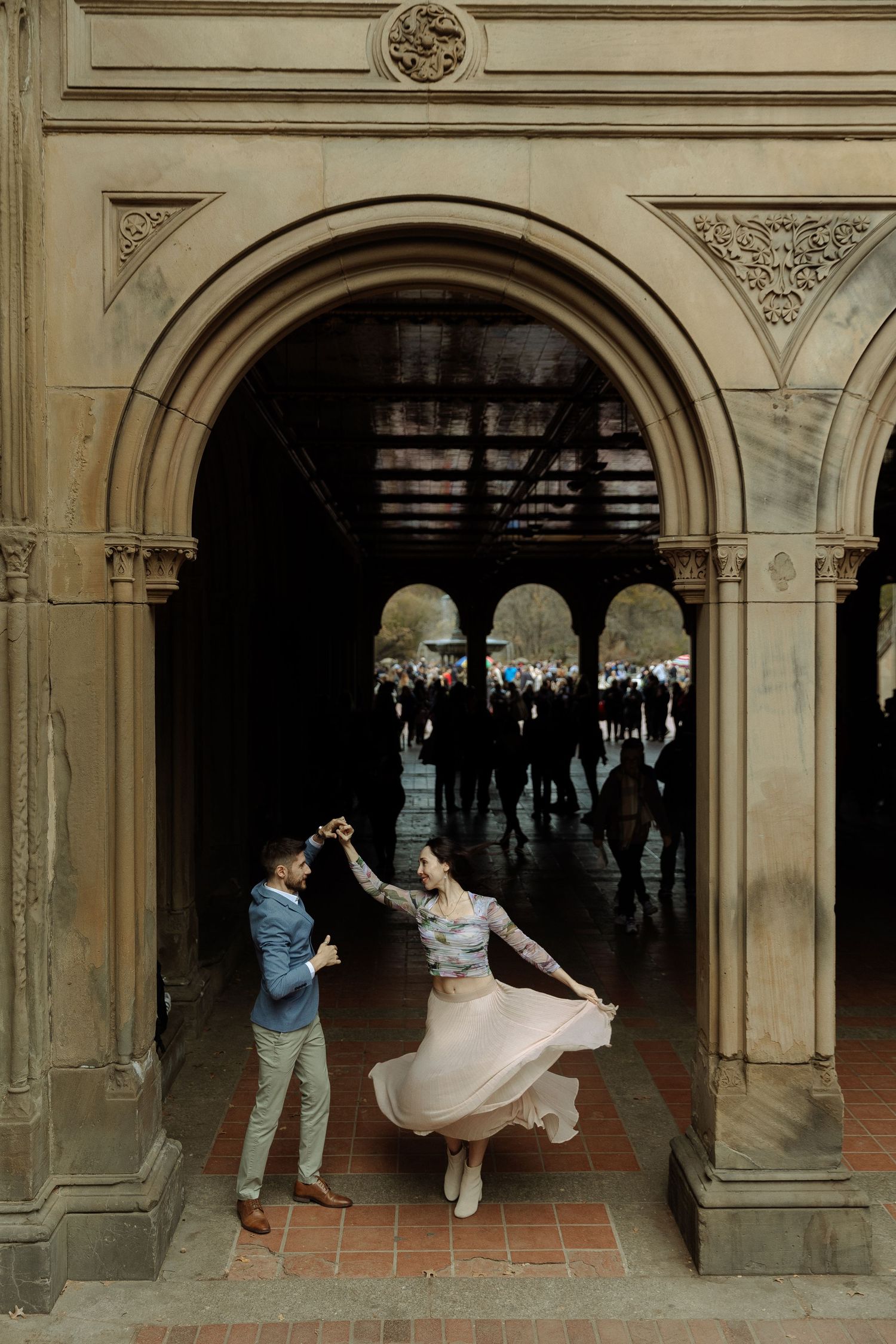 A sequence of photos showing a couple dancing and twirling in an ornate stone archway.
