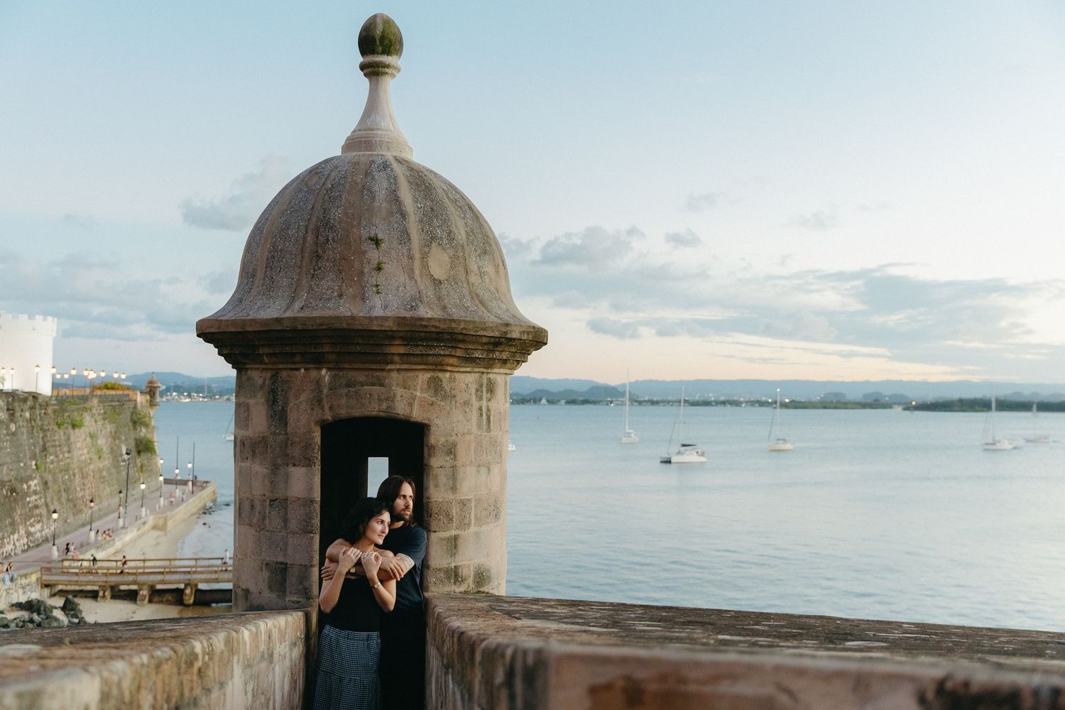 A stone guard tower with arched window overlooks the harbor on a cloudy day at Old San Juan, Puerto Rico.