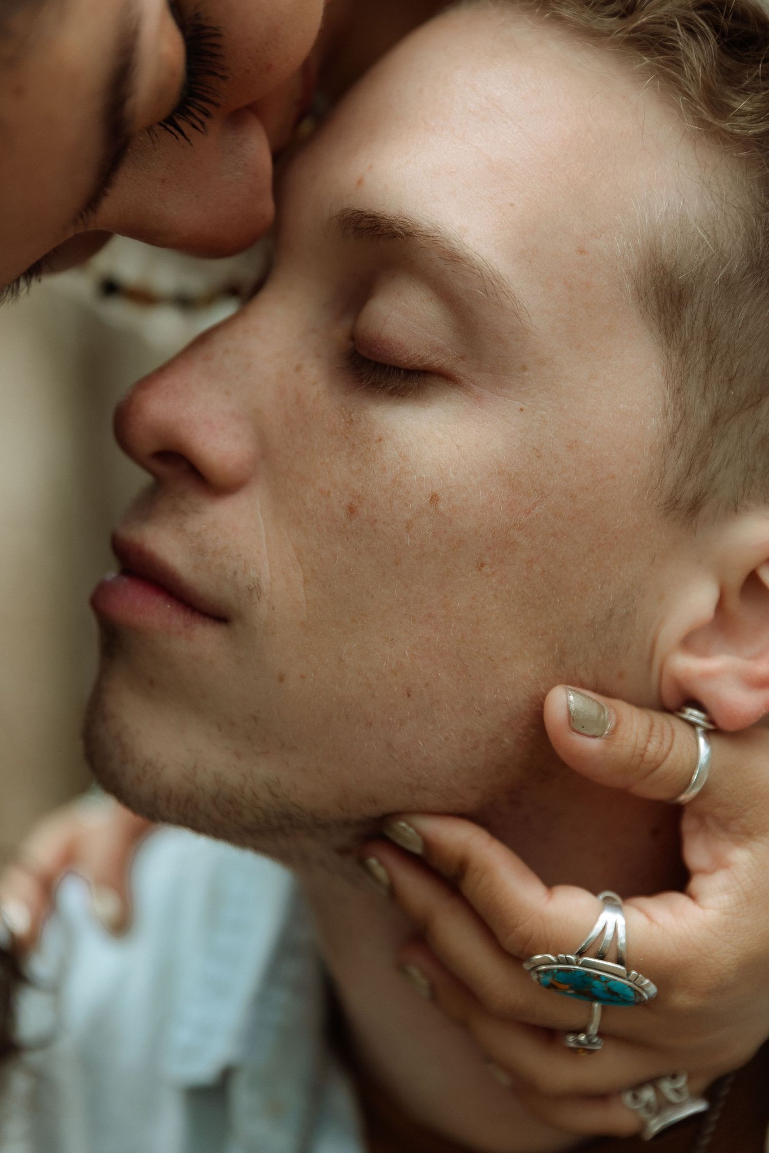 Artistic closeup photo showing intimate tender moment with jewelry details.