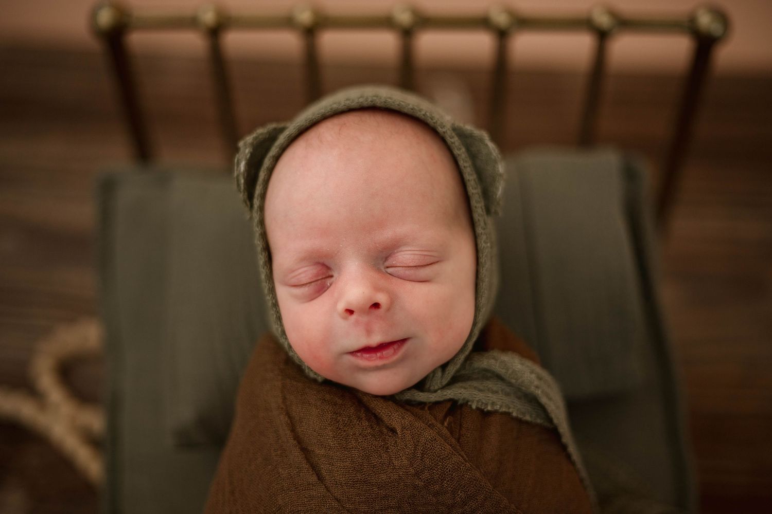 A series of close-up photos showing a sleeping newborn baby wearing a knit hat in warm, natural lighting.