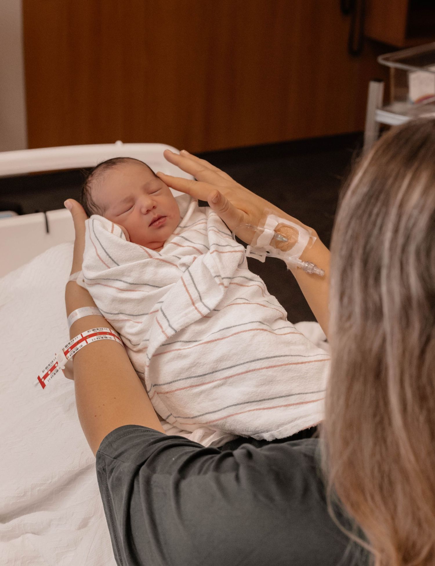 Newborn baby sleeping peacefully in hospital bed.