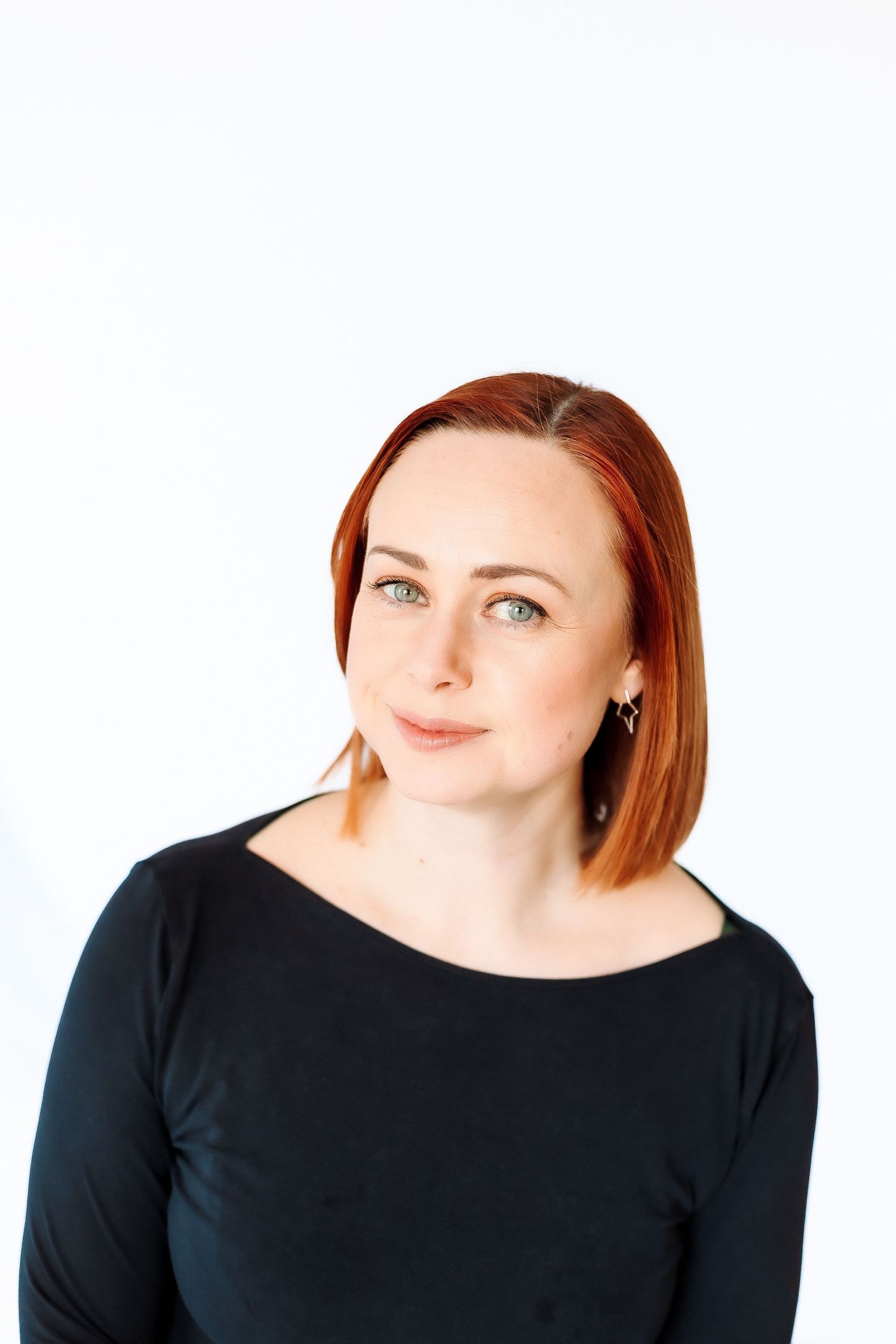A woman with red hair wearing a black top poses in a sequence of three similar portraits against a white background.