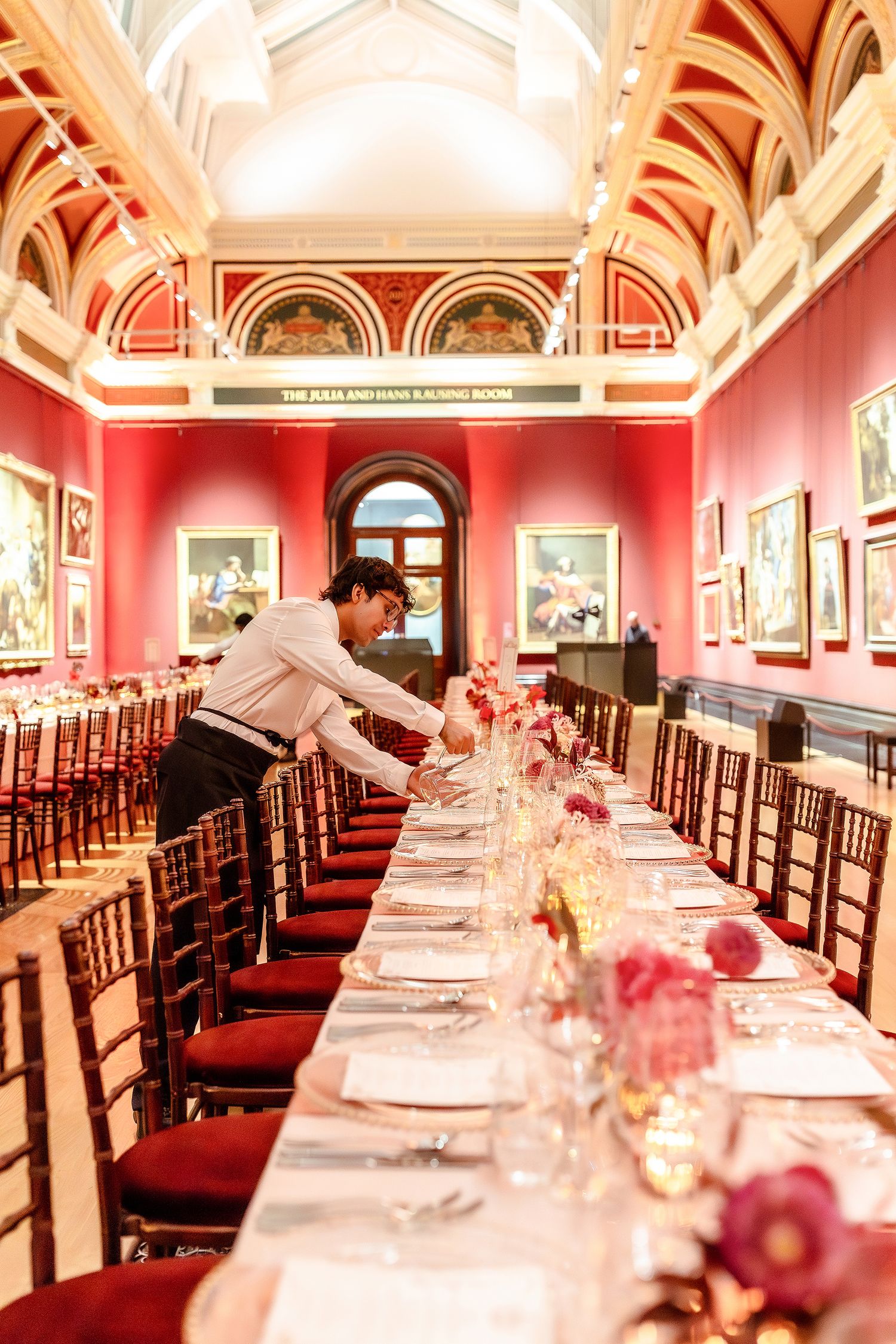 The National Gallery London Event birthday dinner as a waiter arranges place settings.