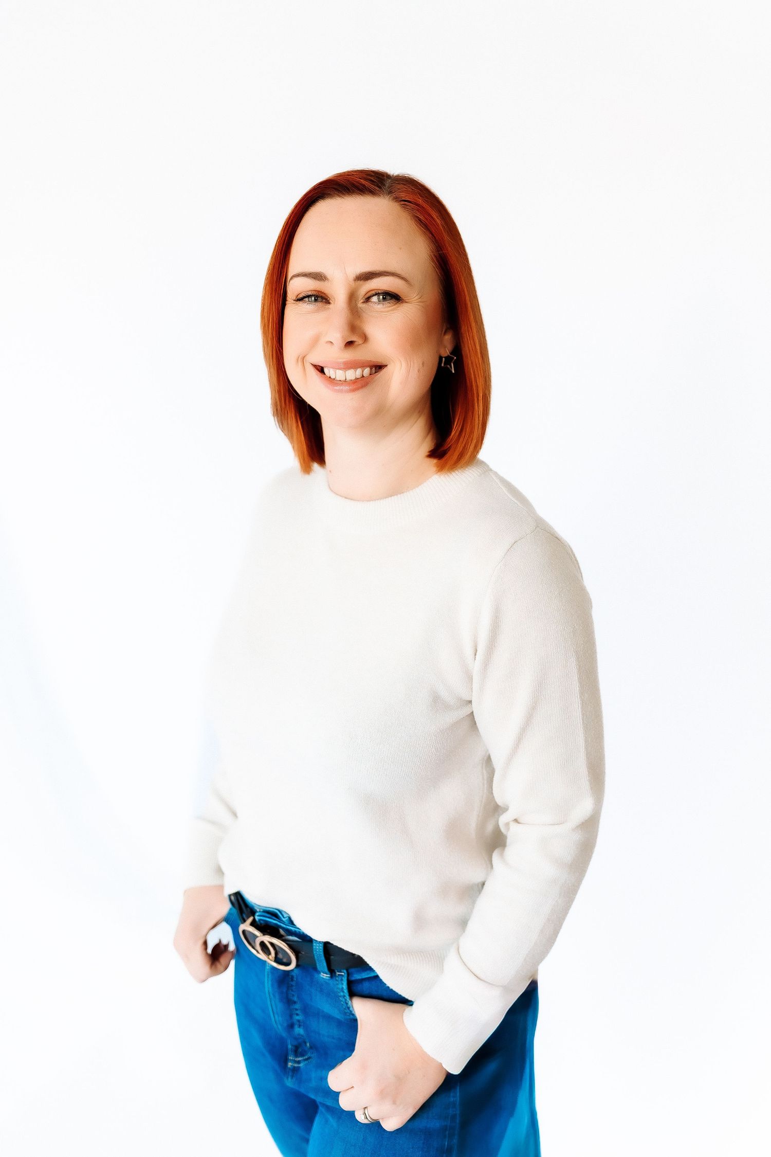 A person wearing a white sweater and blue jeans poses against a white background in three similar poses.