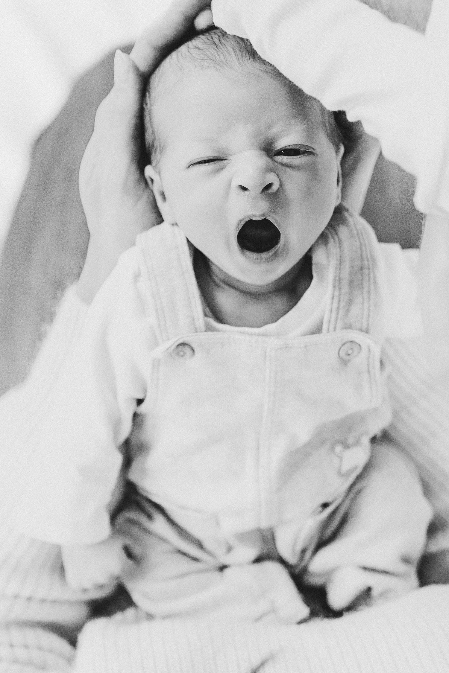 Series of expressive newborn baby moments captured in black and white photography.