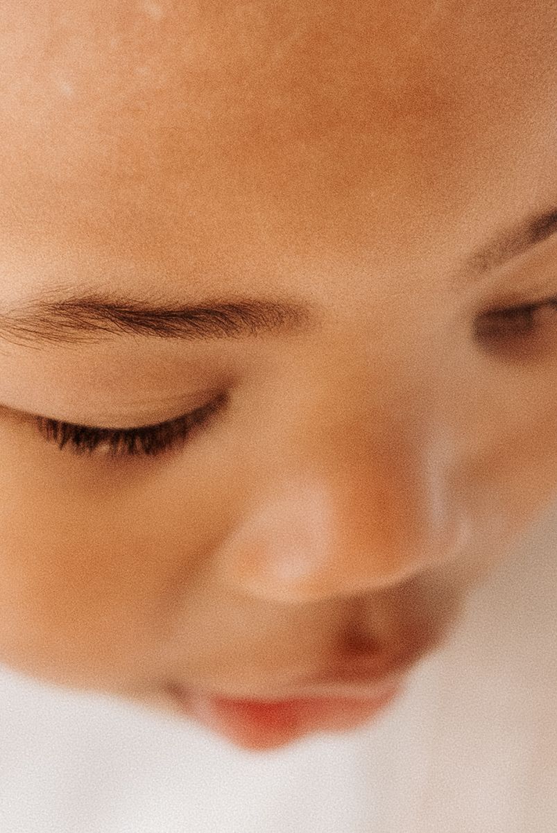 Shepperton Surrey photography studio. Close-up macro shot showing eyelashes and facial features in warm brown tones with soft lighting.