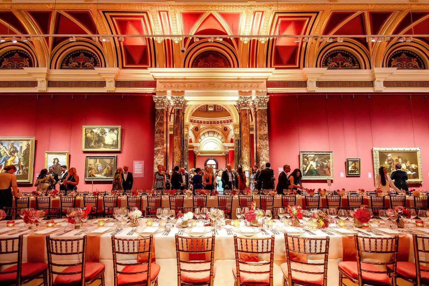 The National Gallery London Event birthday dinner Elegant red-walled museum dining hall with ornate gold ceiling, fine table setting