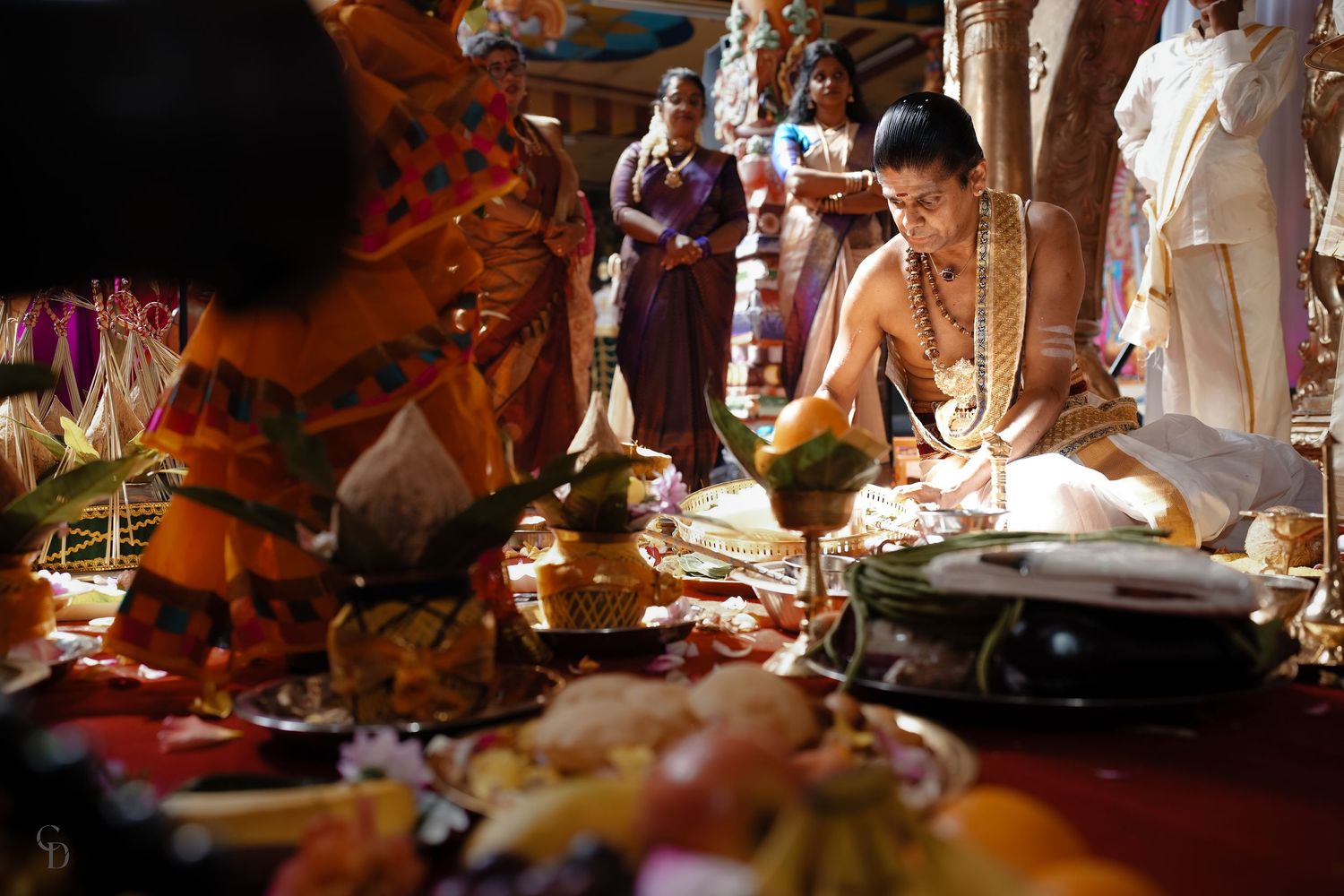 Traditional Hindu wedding ceremony with elaborate ritual offerings and decorations arranged on the ground.
