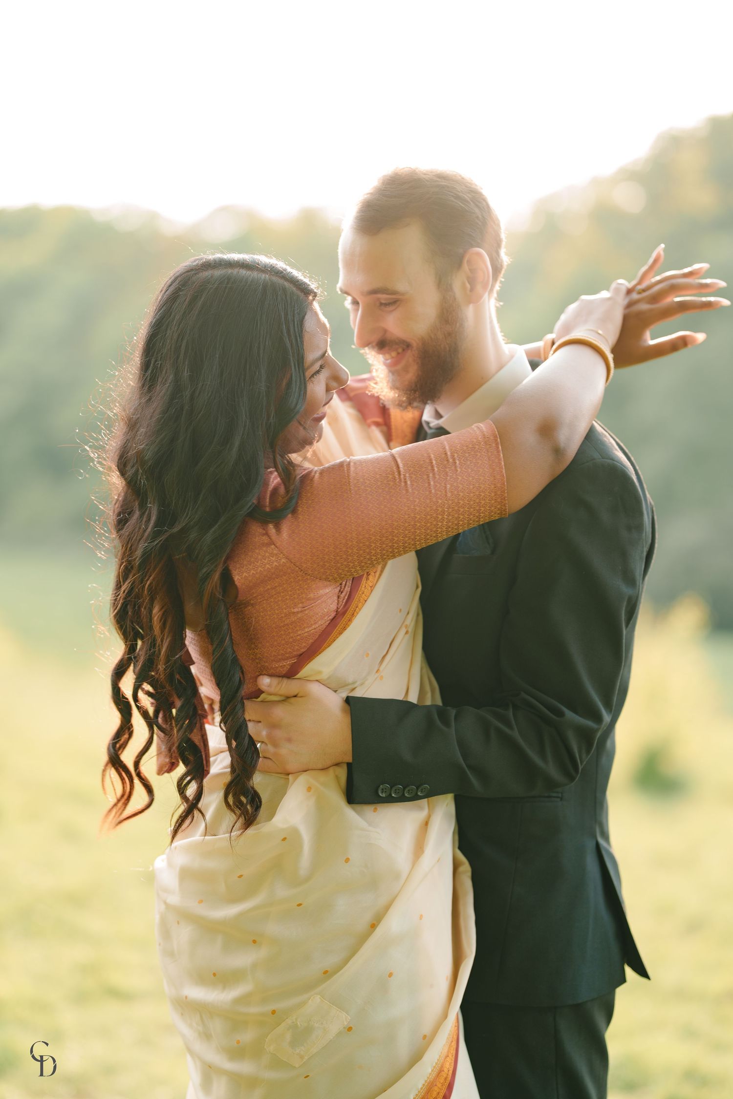 Dancing couple in mixed traditional and modern wedding attire during sunset.