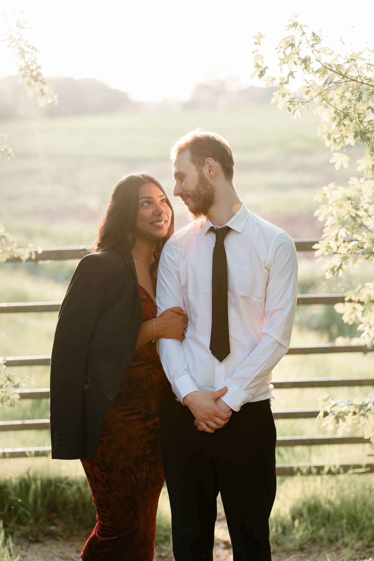 Romantic outdoor portrait of couple in formal wear sharing intimate moment against natural backdrop.
