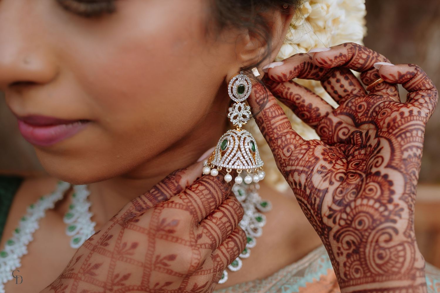 Detailed mehndi design on hands with traditional Indian jewelry and bridal accessories.