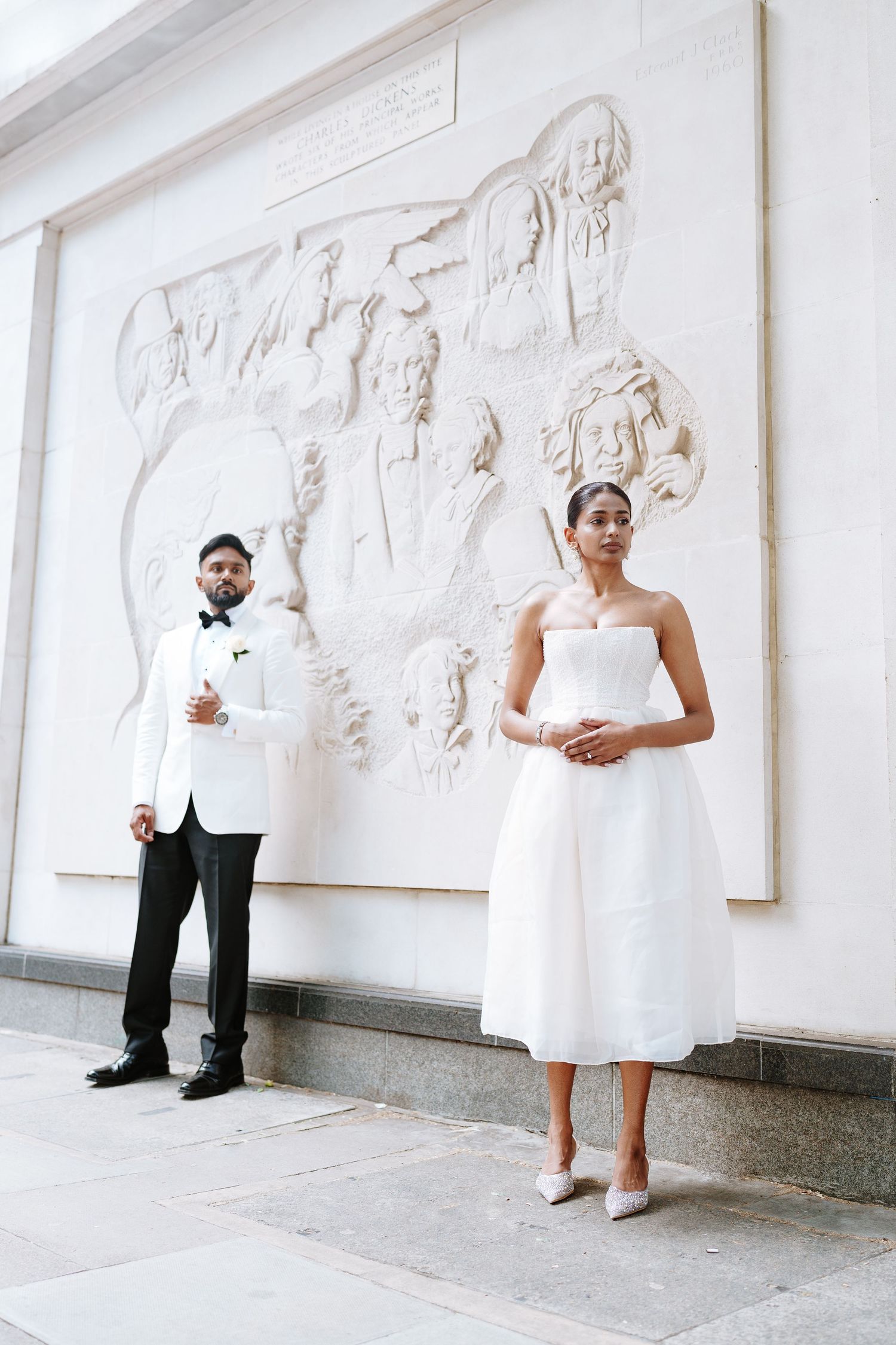 A sequence of five artistic wedding photos showing the couple interacting with a white wall containing sculptural reliefs.