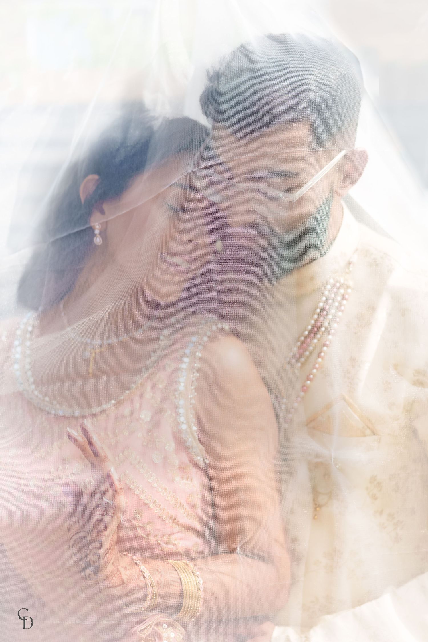 Dreamy soft-focus portrait of couple in traditional Indian wedding attire.