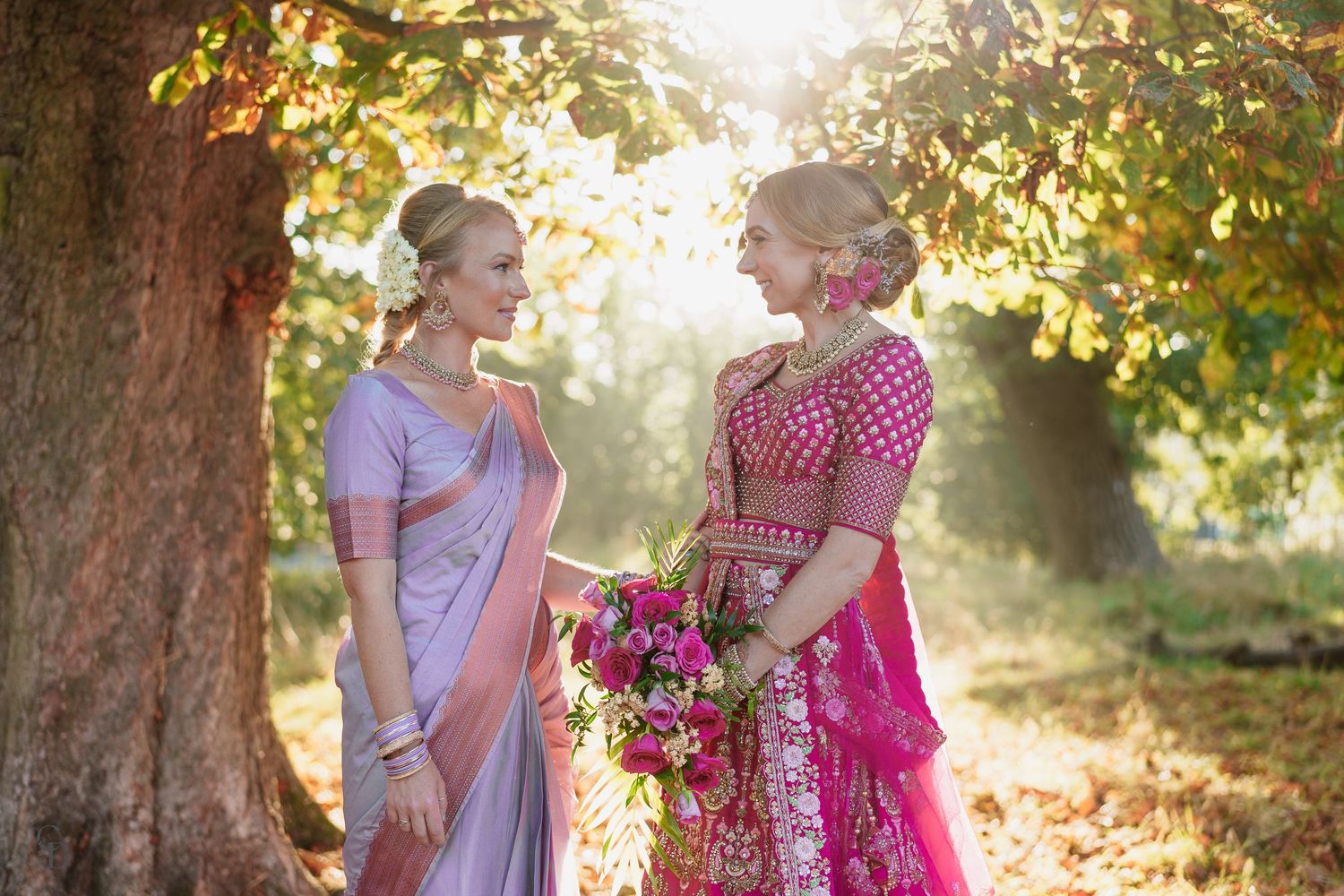 Two people in traditional Indian attire sharing a moment outdoors.