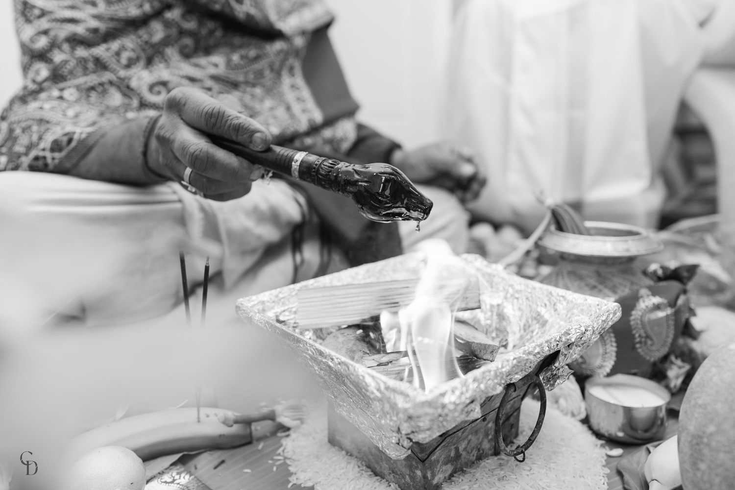 Traditional ceremonial items with incense smoke in black and white photography.