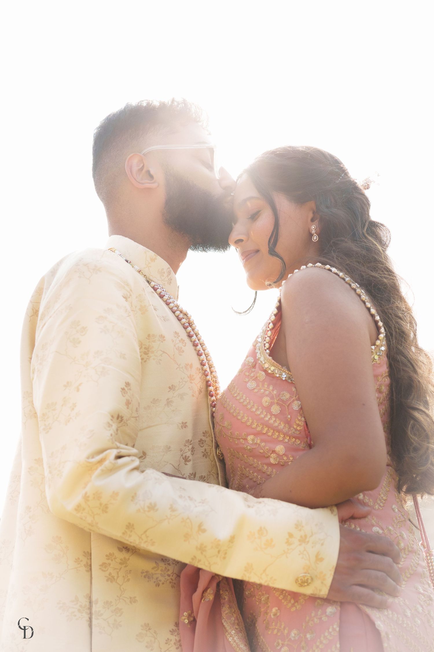 Sun-kissed portrait of couple in traditional Indian formal wear.