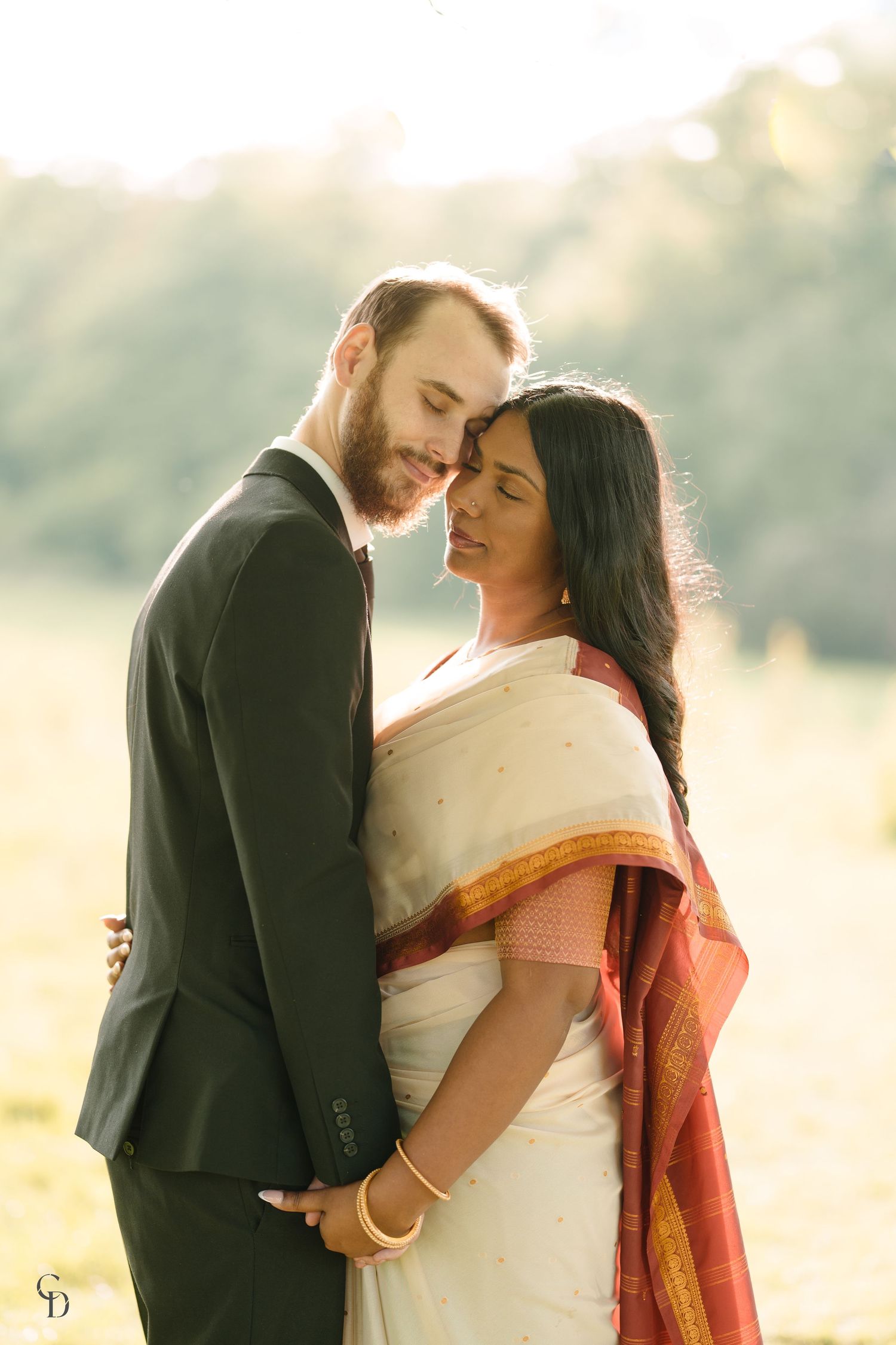 Romantic couple portrait combining traditional Indian sari with western formal wear.