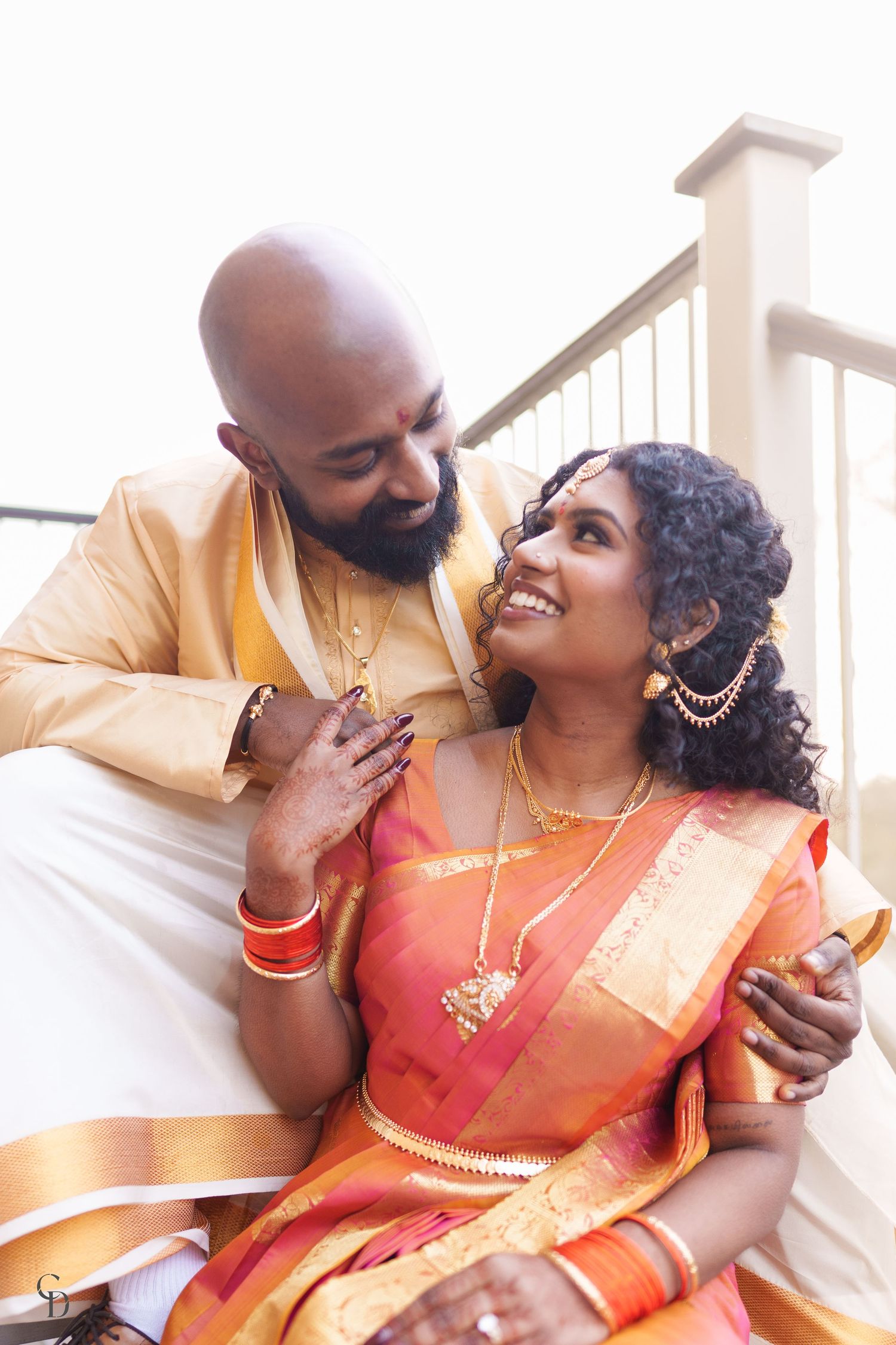 A candid moment of joy between newlyweds in traditional South Asian wedding attire.