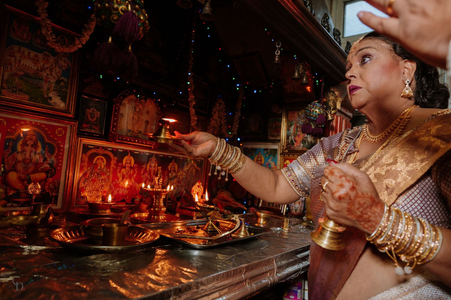 Person performing traditional Hindu wedding rituals with ceremonial items.