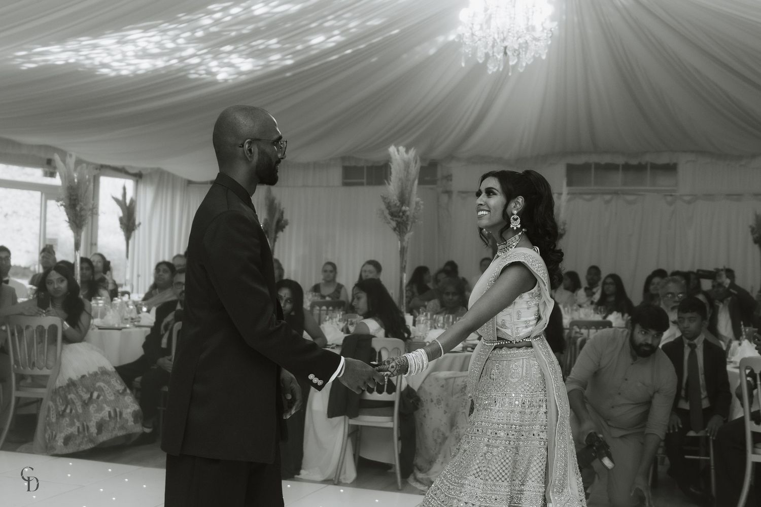 A couple dancing at their wedding reception in an elegantly decorated tent venue.