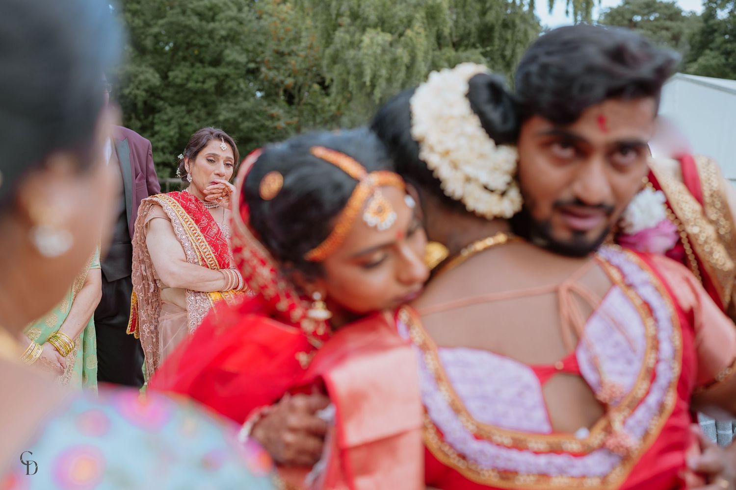 Emotional moment during traditional Indian wedding ceremony with colorful attire.