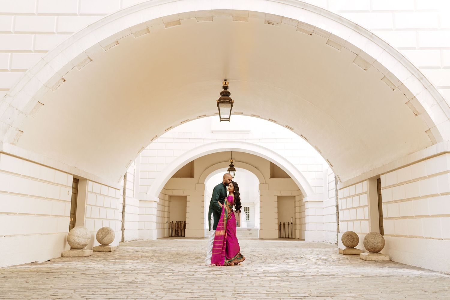 A series of five architectural white arched courtyards creating a symmetrical repeating pattern with stone walls.