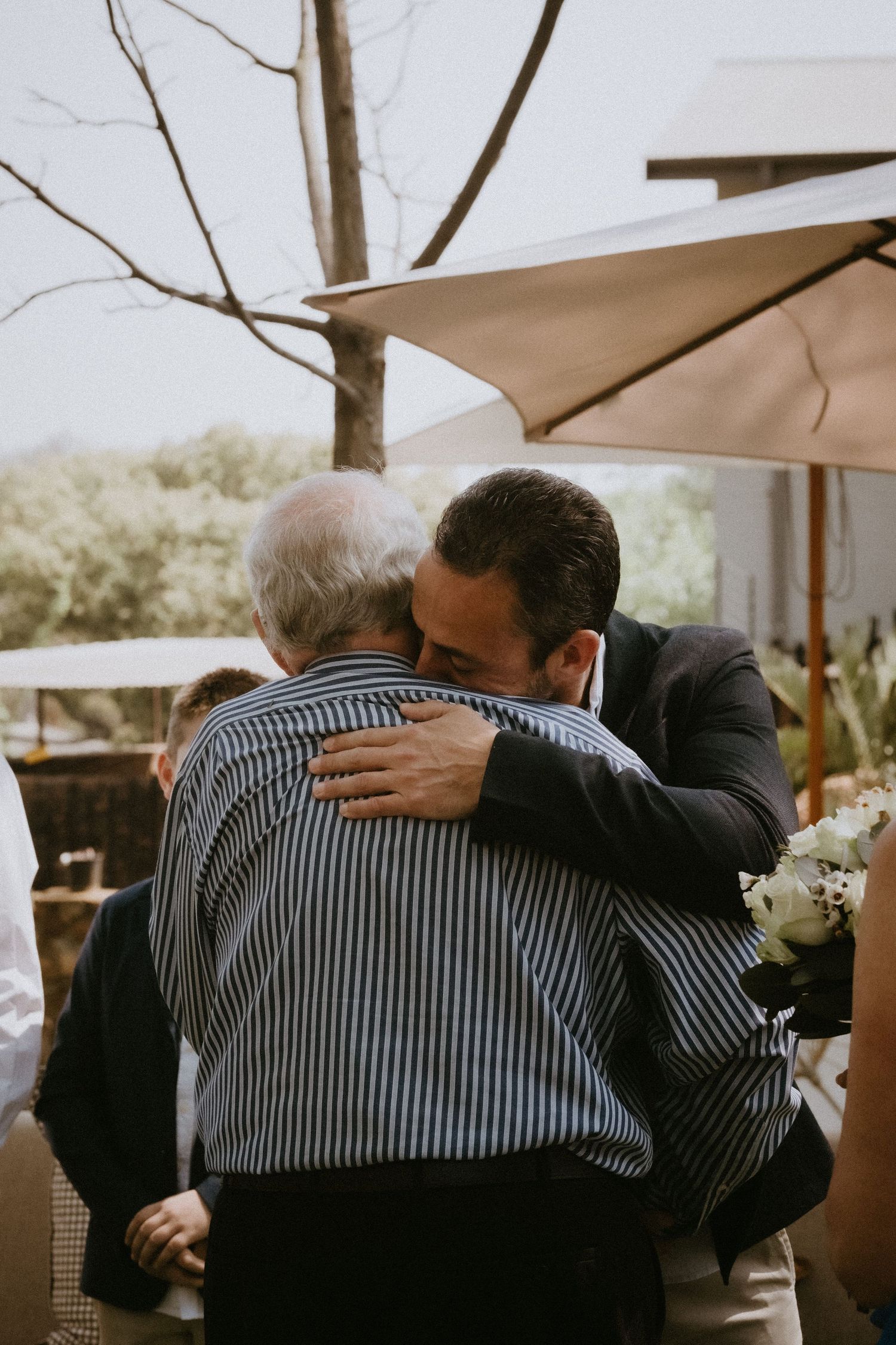 Groom hugs father of the bride