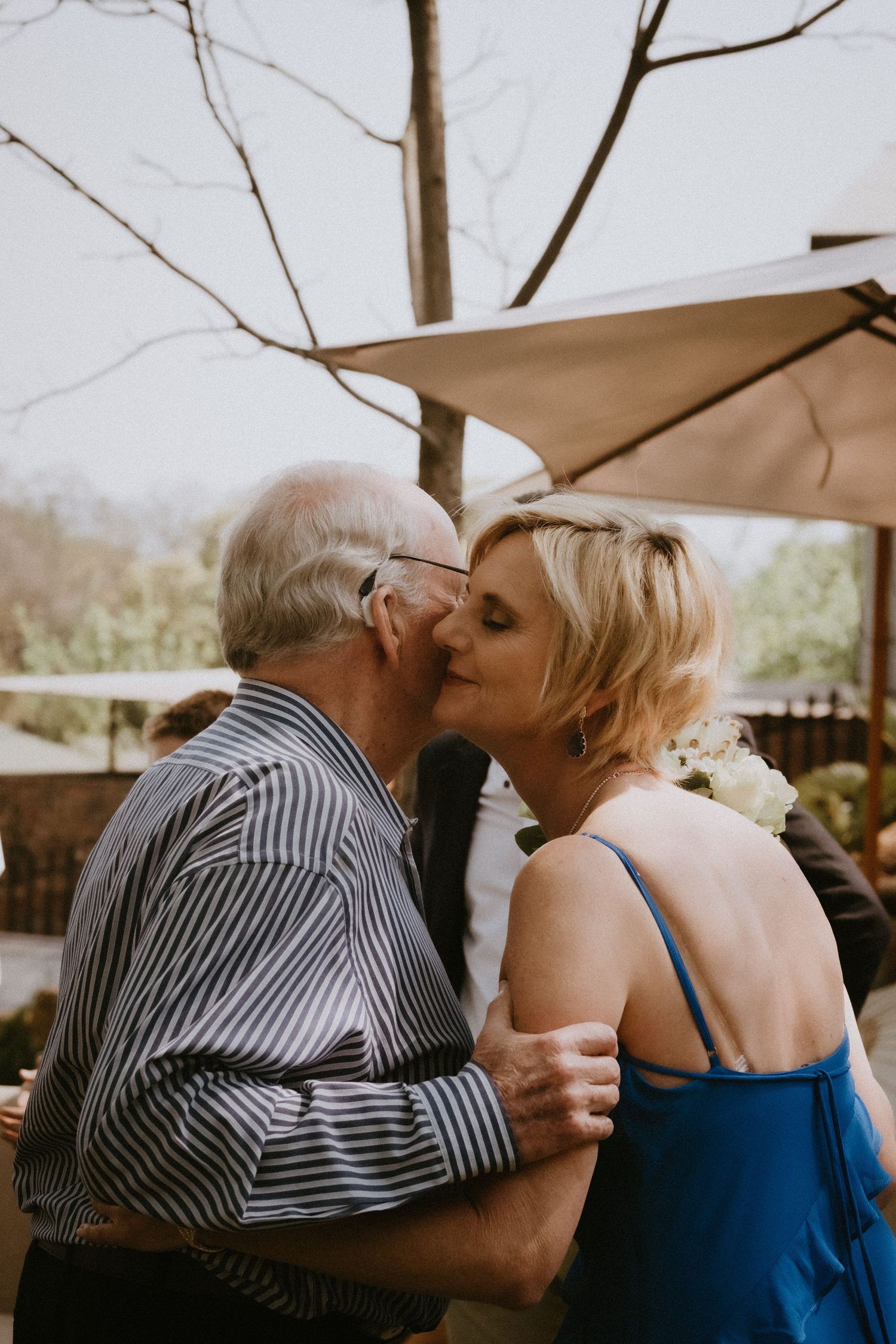 Father of the bride kisses her on the cheek in a touching moment