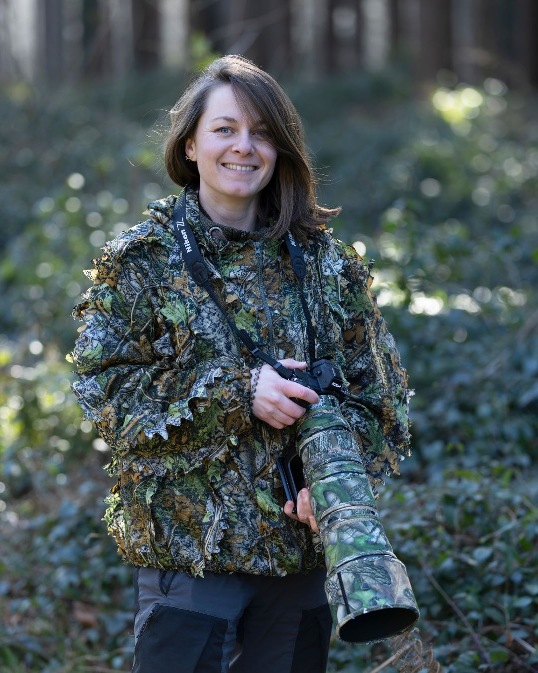 Julie votre guide et photographe en habit de camouflage avec son appareil photo