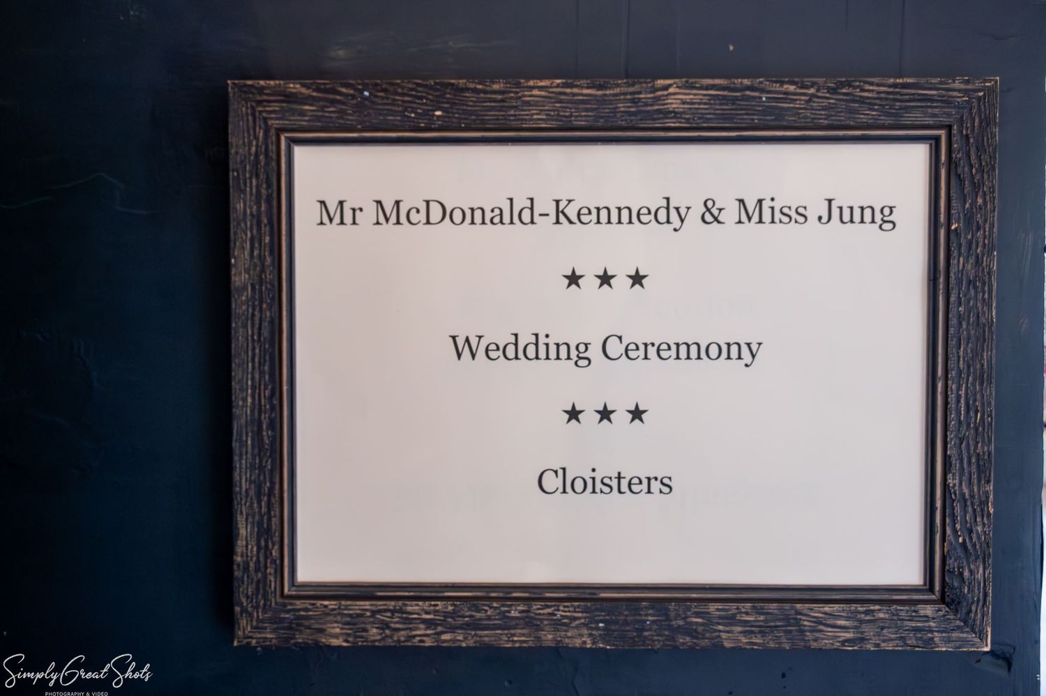A framed welcome sign for Mark and Minky's wedding ceremony in The Cloisters room at Coombe Abbey.