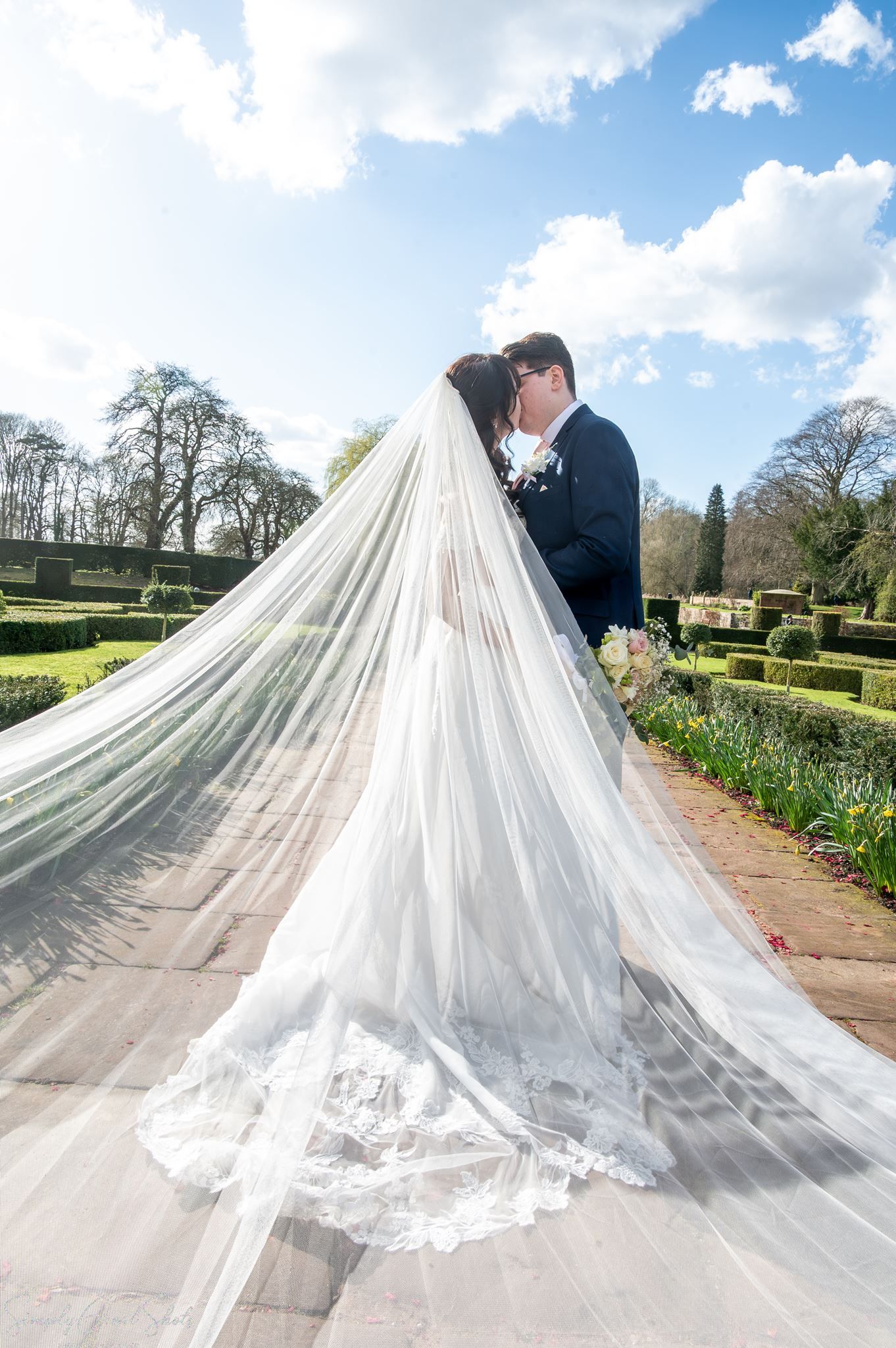 SimplyGreatShots couple portraits of Mark and Minky kissing under a long veil in Coombe Abbey gardens.