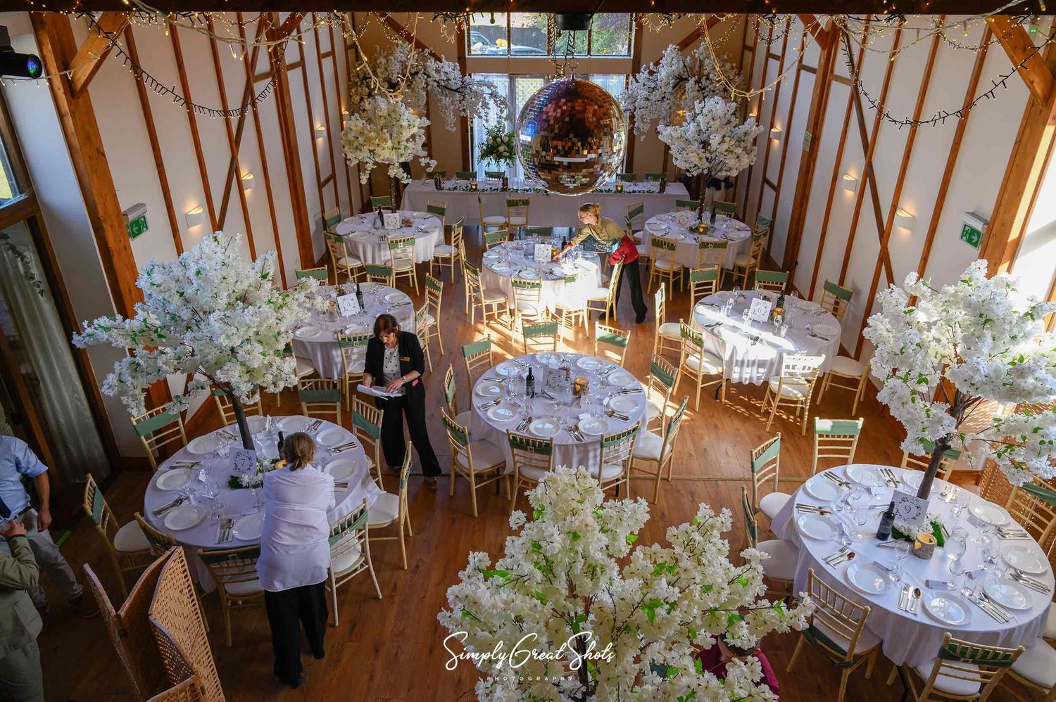 Winters Tale Country Barn wedding breakfast table settings with sage chair Sachs. Photographed by SimplyGreatShots Wedding Photographers