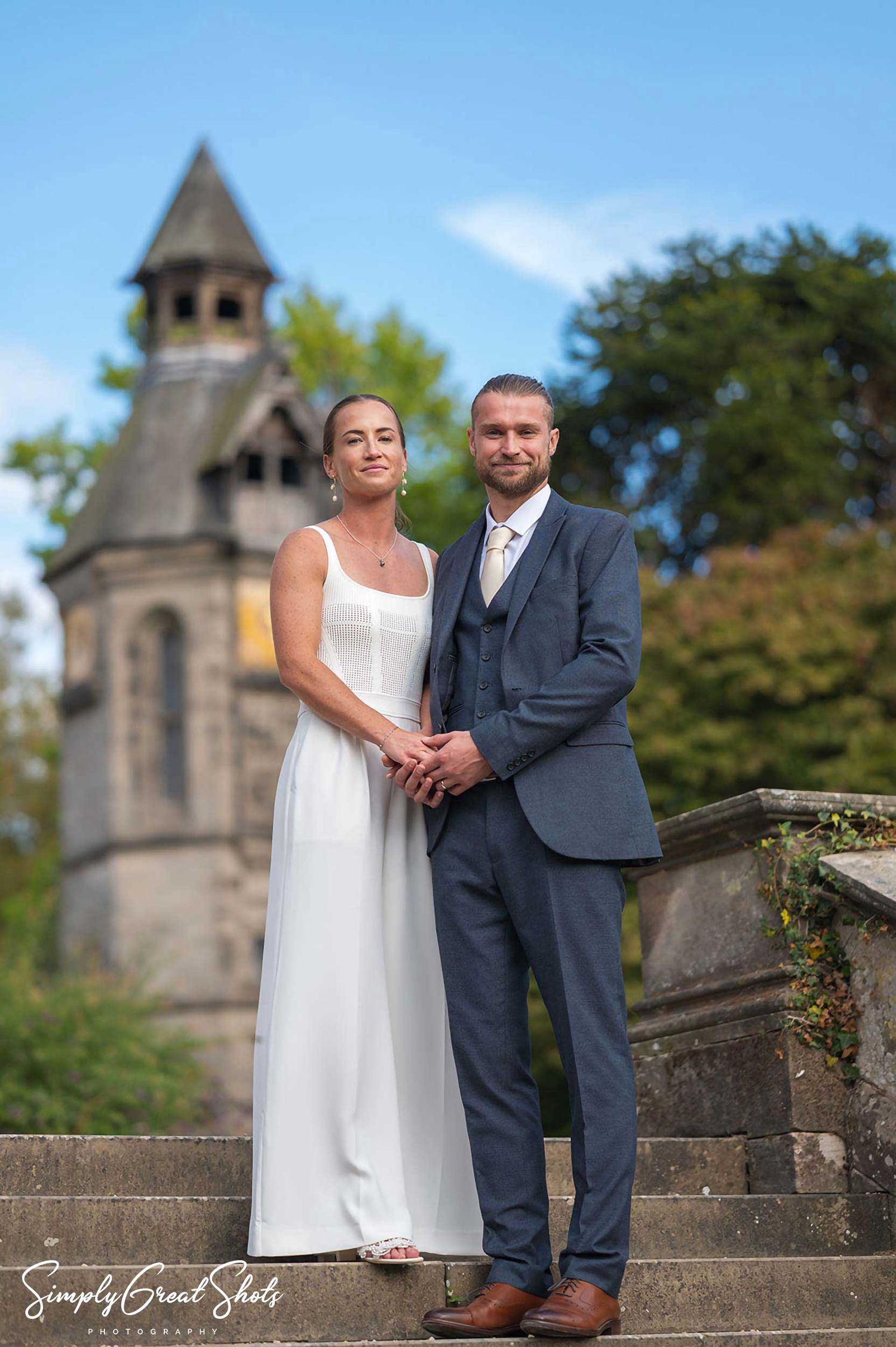 Hampton Manor wedding photographer captures the bride and groom posing in front of the clock tower