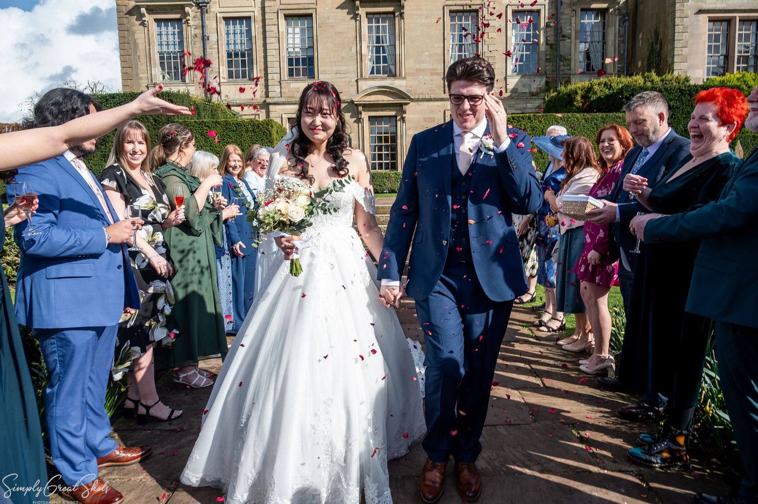 SimplyGreatShots capturing guests throwing confetti over bride Minky and groom Mark at Coombe Abbey.
