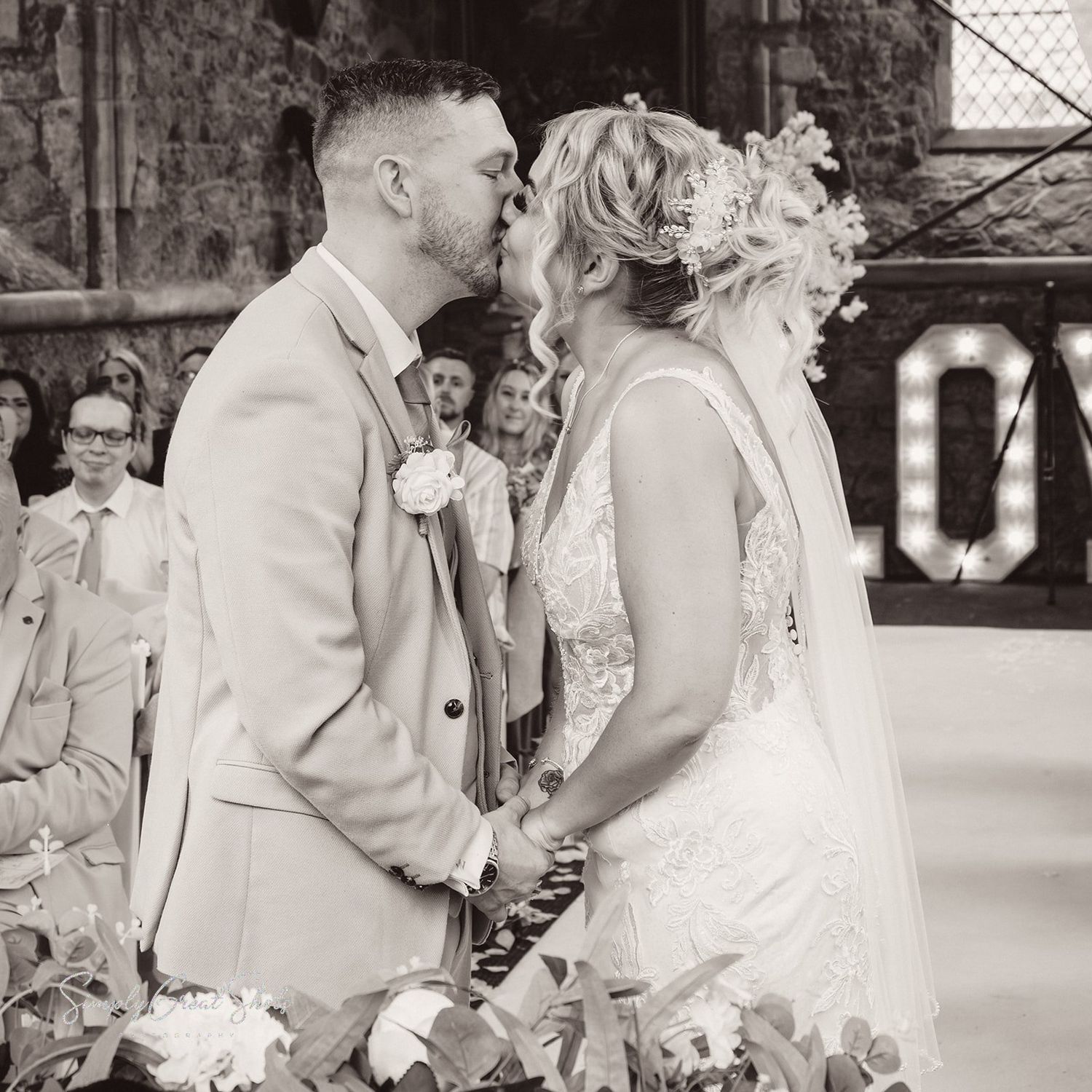 A newlywed couple share tender moments in a black and white photo during their romantic wedding celebration.