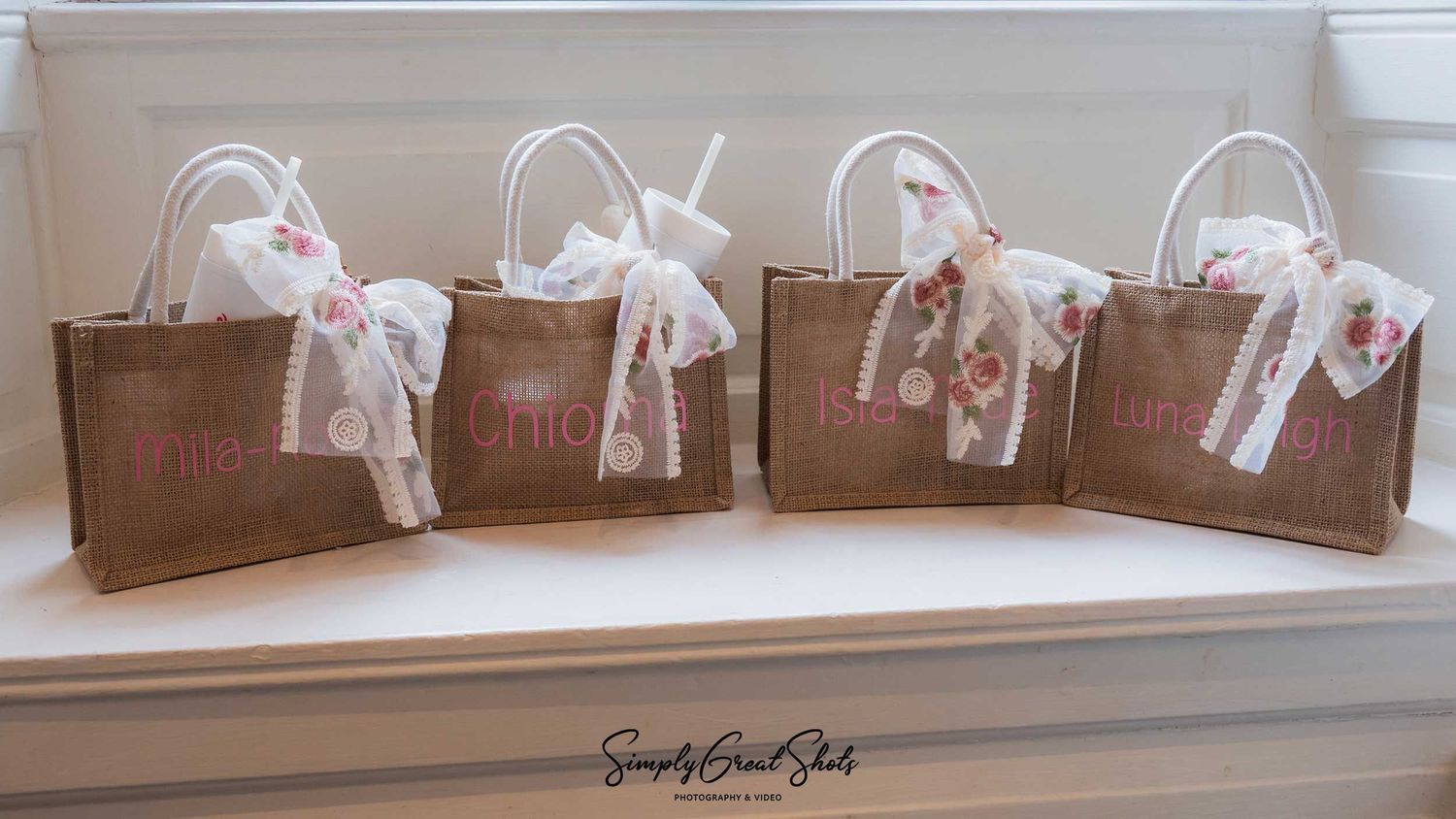 Personalised bridesmaids' bags with individual names and floral bows at Rothley Court wedding.