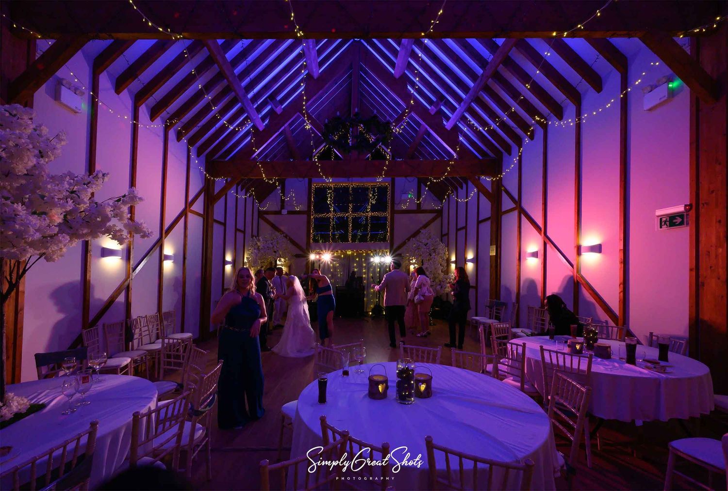 The bride, groom and guests dance the night away with beautiful lighting inside the barn at the Winters Tale Country Barn Wedding venue