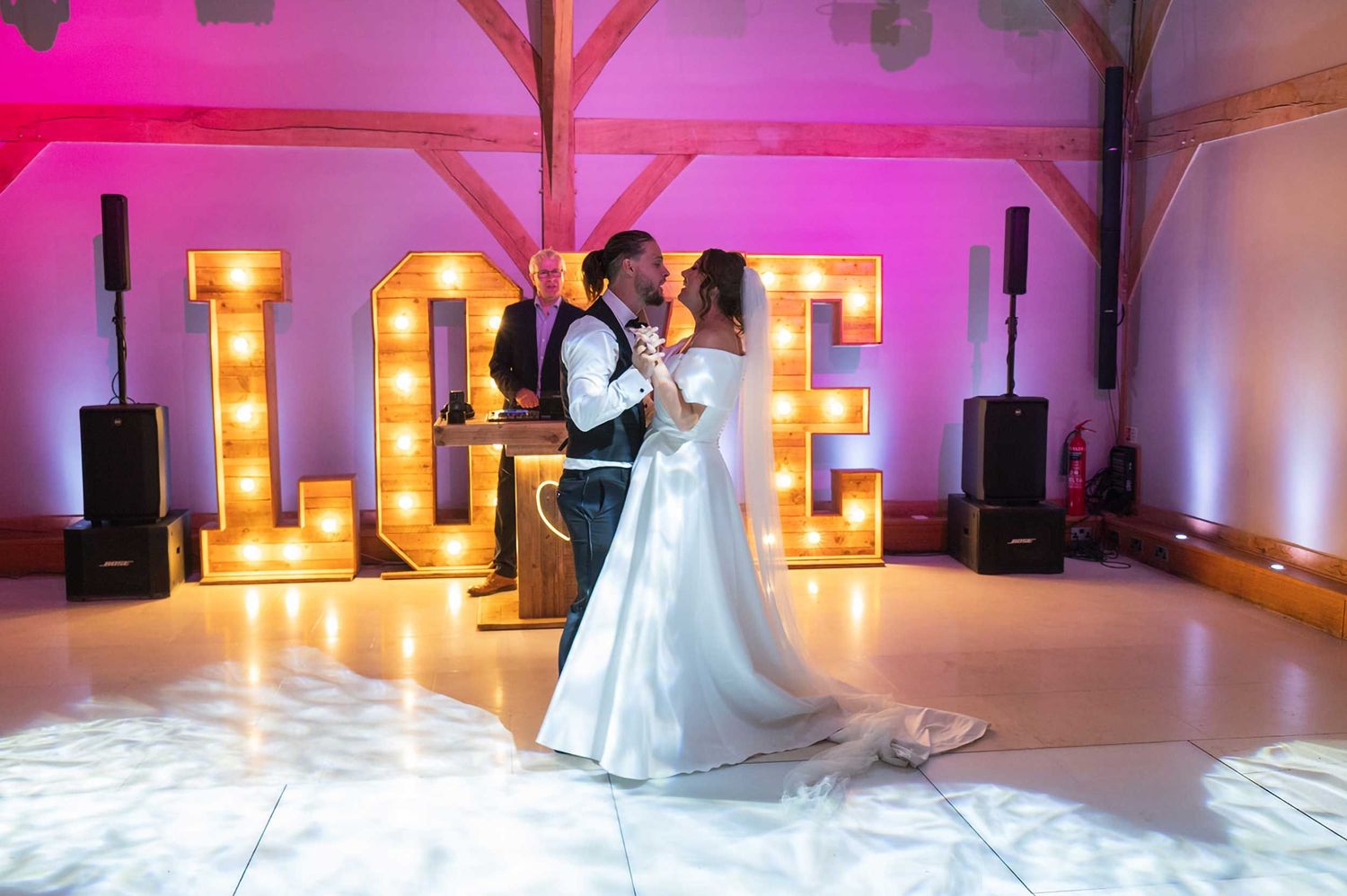 Redhouse Barn wedding photographer capturing first dance with illuminated LOVE letters and romantic lighting
