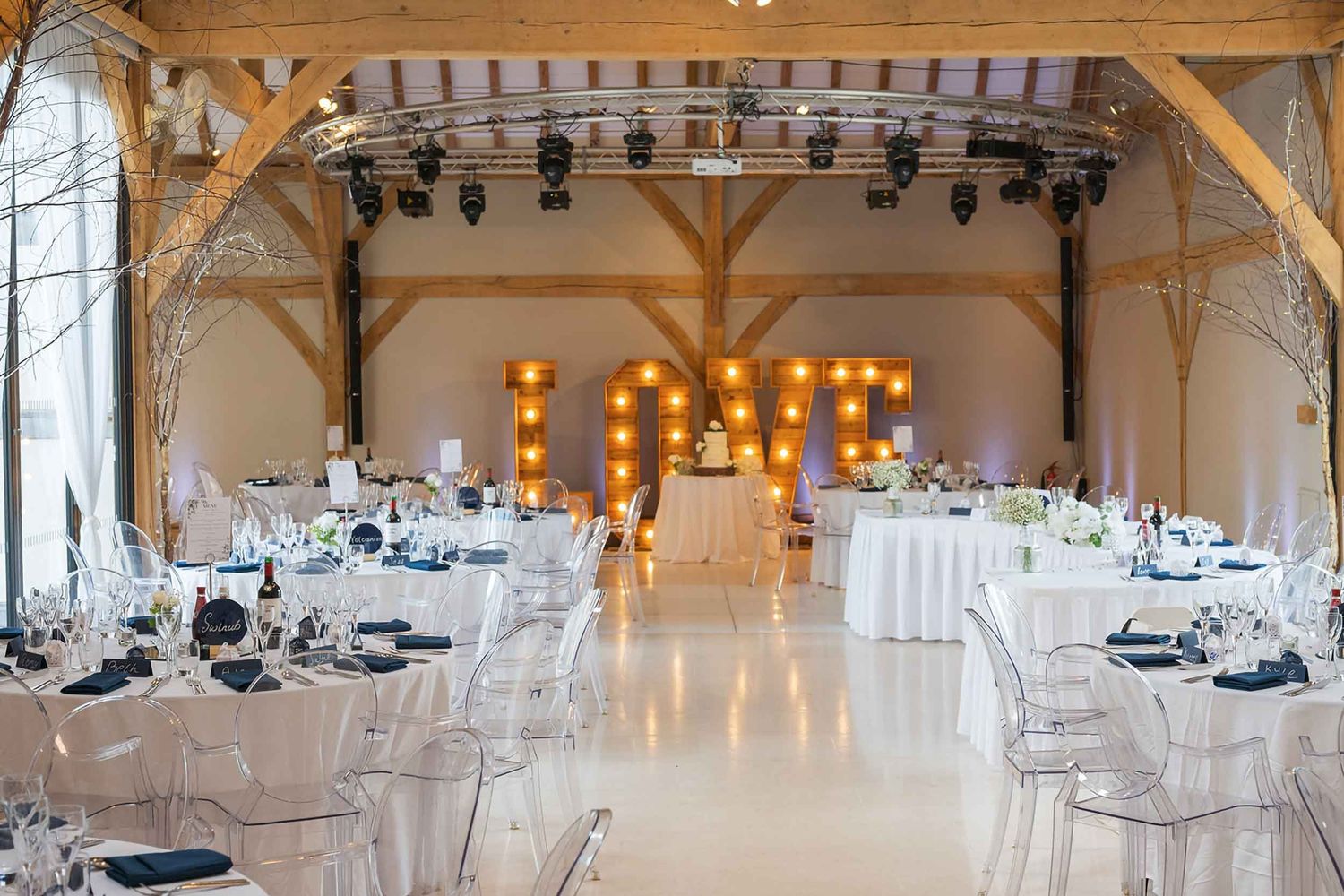 Redhouse Barn wedding photographer documenting reception setup with illuminated LOVE sign in rustic barn space