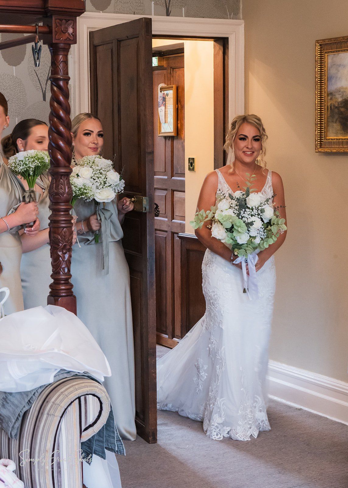 A bride reveal in a white lace wedding gown with a white and green floral bouquet.