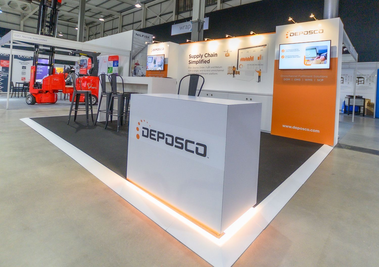 Modern trade show booth display with illuminated Depasco company branding and product demonstration areas.