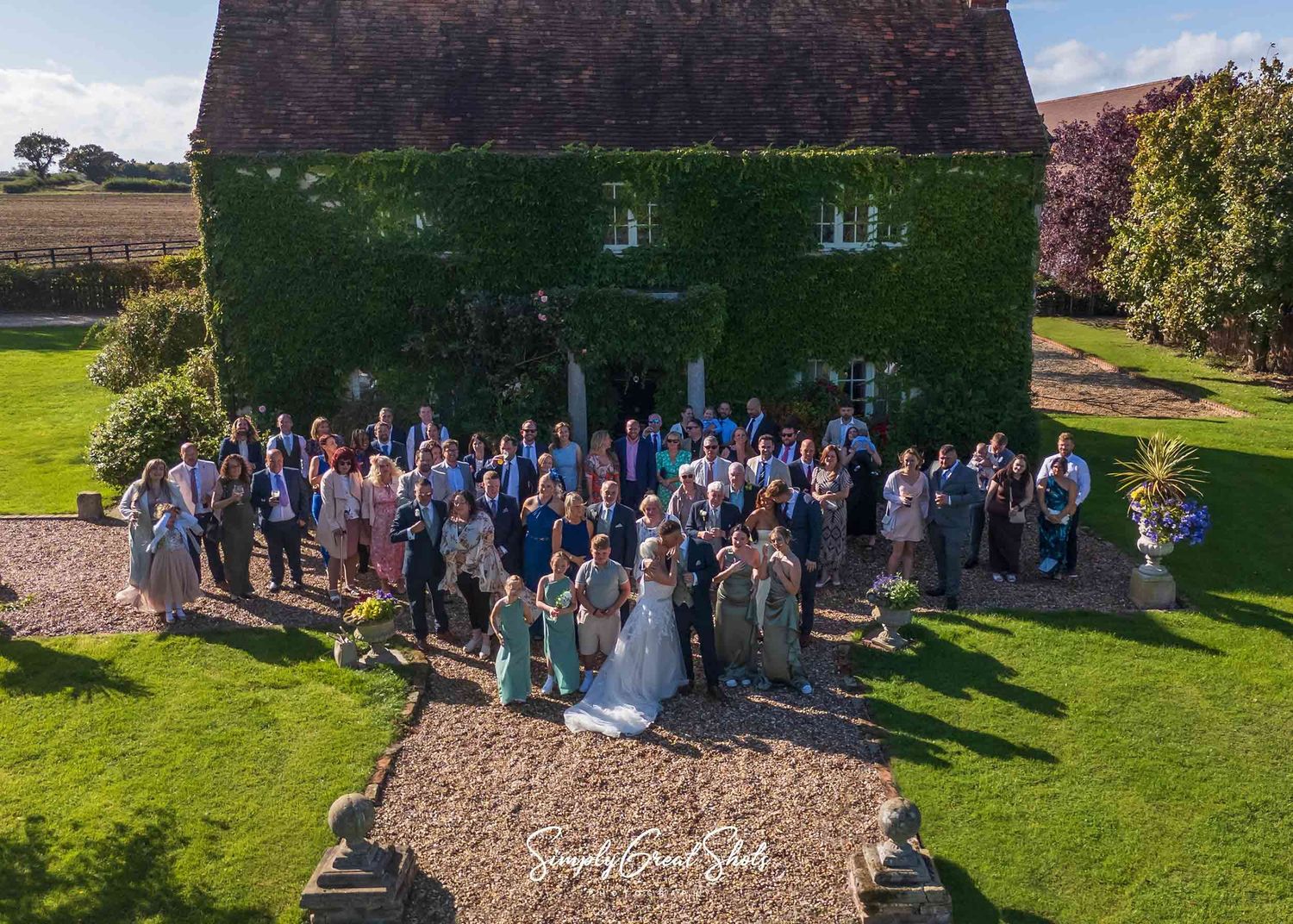 The wedding party in front of the 17th century farmhouse at Winters Tale Country Barn taken by a wedding photographer.
