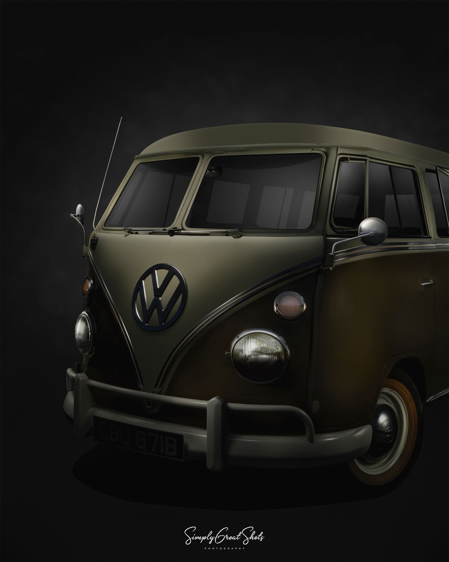A vintage olive green Volkswagen Type 2 van photographed against a dark background in dramatic lighting.