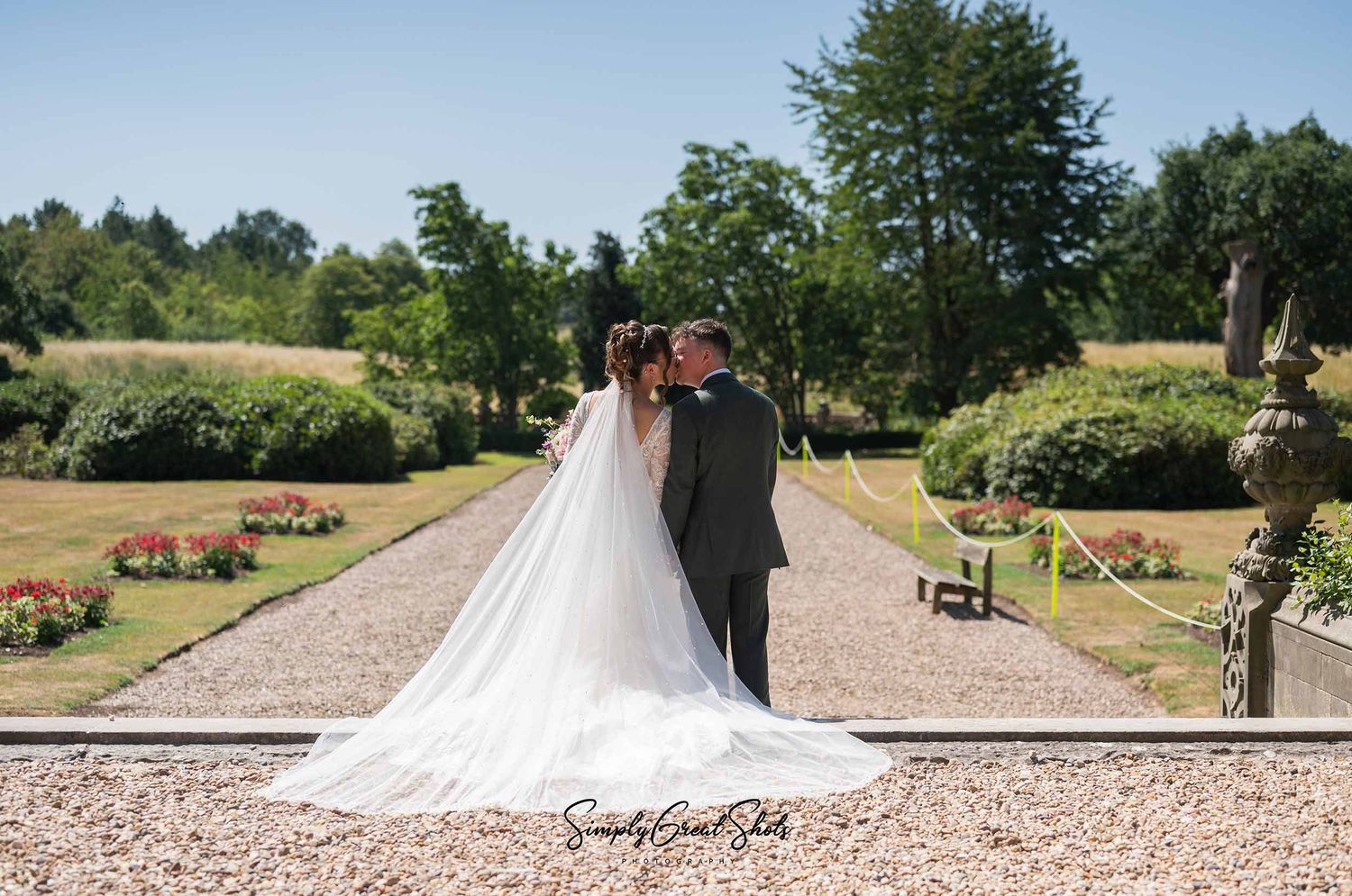 Beaumanor Hall wedding photographer captures a bride and groom sharing a kiss in the stunning landscape gardens