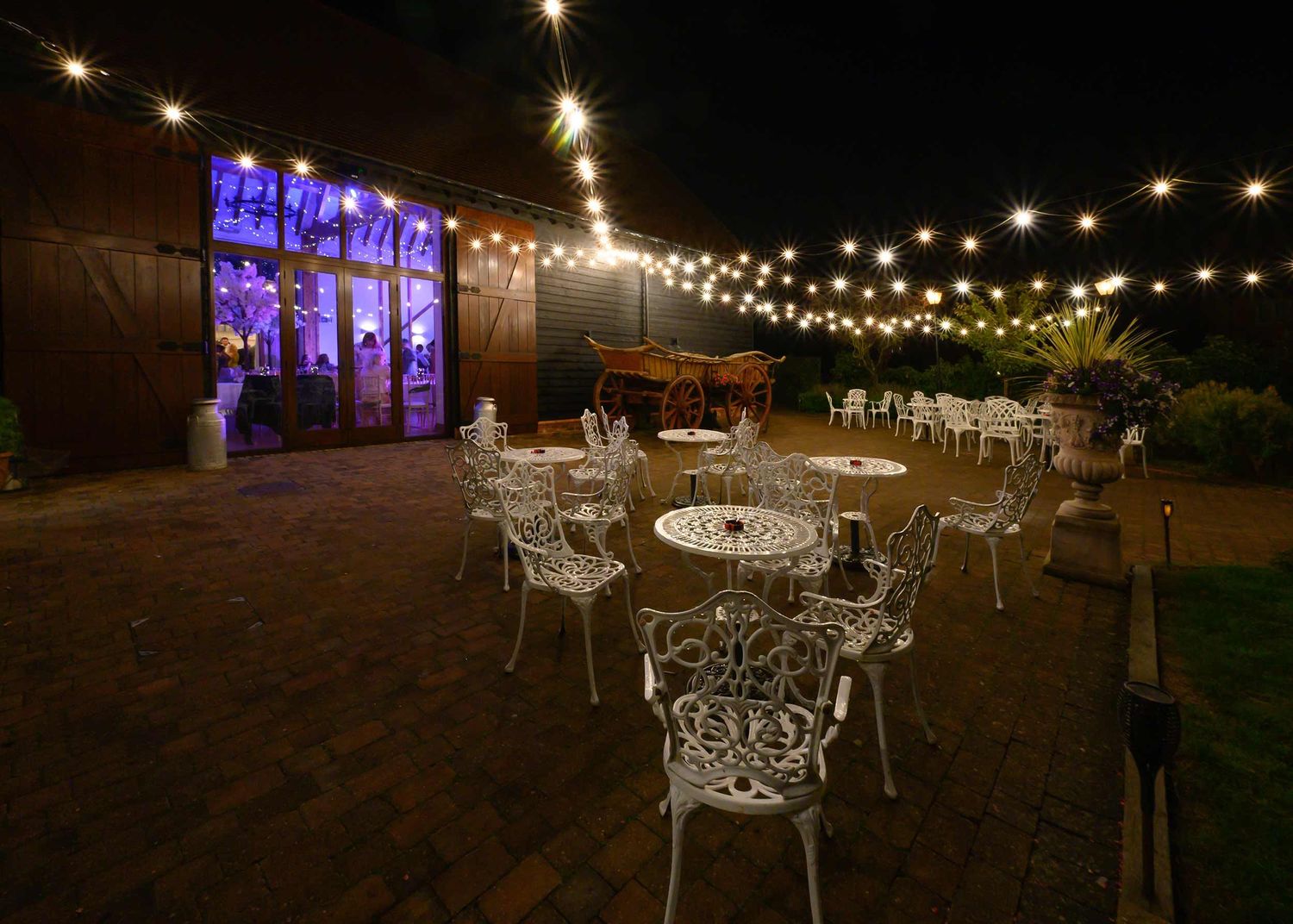 Winters Tale Country Barn wedding photographer captures the courtyard by night with beautiful starbursts from the over head lighting.