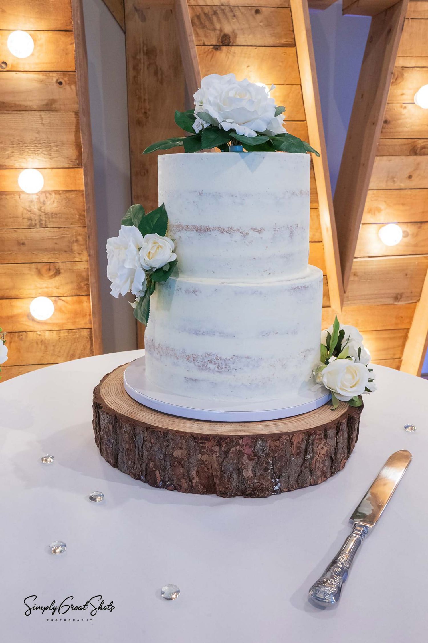 Antsy hall wedding photographer captures a beautiful two-tiered wedding cake with fresh flowers, on display at a wedding.