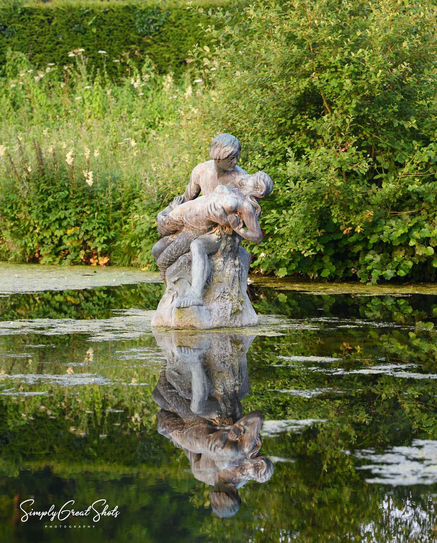 Coombe Abbey wedding photography location featuring historic bronze statue by Percy George Bentham in landscaped gardens