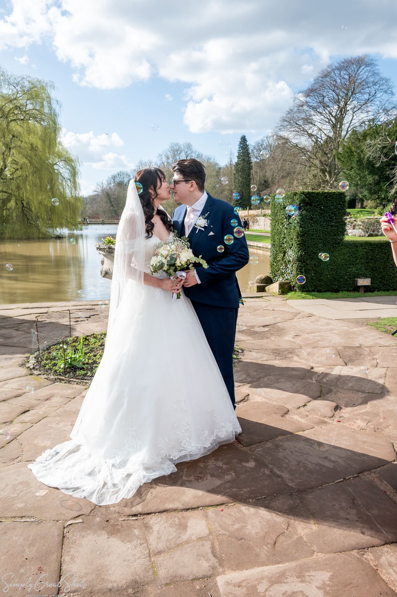 SimplyGreatShots couple portraits of Mark and Minky kissing with bubbles and lake in the background at Coombe Abbey.