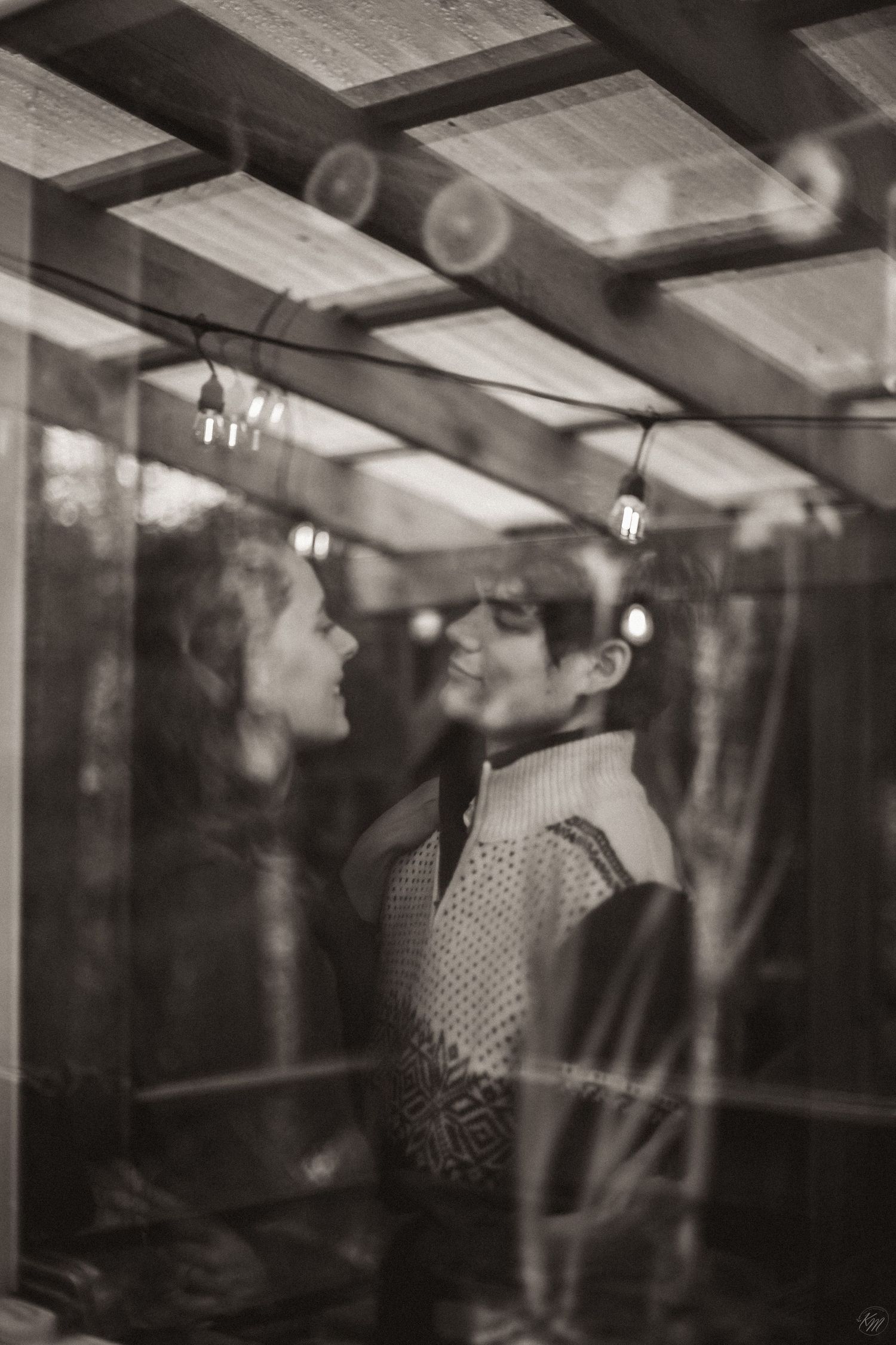 A romantic black and white photograph taken through a window with vintage lighting and reflections in Southeast Alaska.