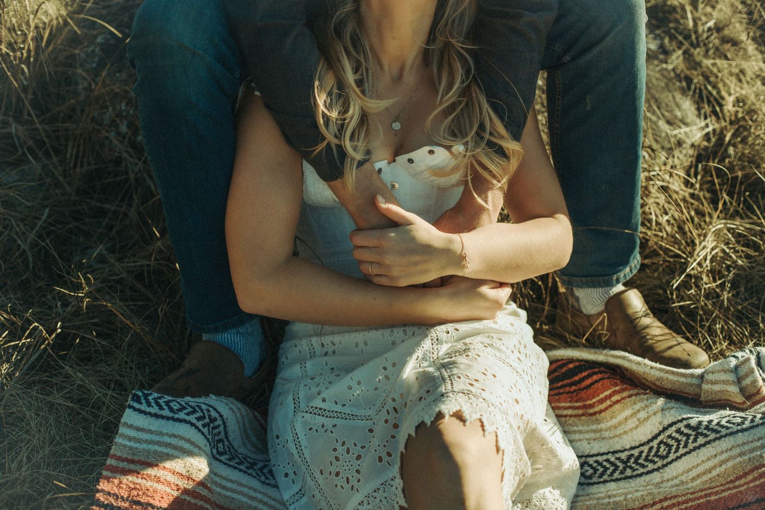 Someone sitting on a patterned blanket outdoors  while relaxing in the grass in Southeast Alaska.